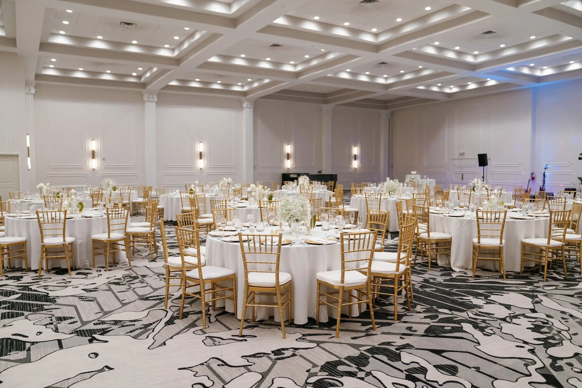 Elegant Ballroom White and Gold Wedding Reception Inspiration | Gold Chiavari Chairs at Round Tables with White Linens Decor Ideas | Gold Chargers with White Napkins and Romantic White Floral Centerpieces with Tea Candles Decor Inspiration | Historic Tampa Venue Hotel Flor