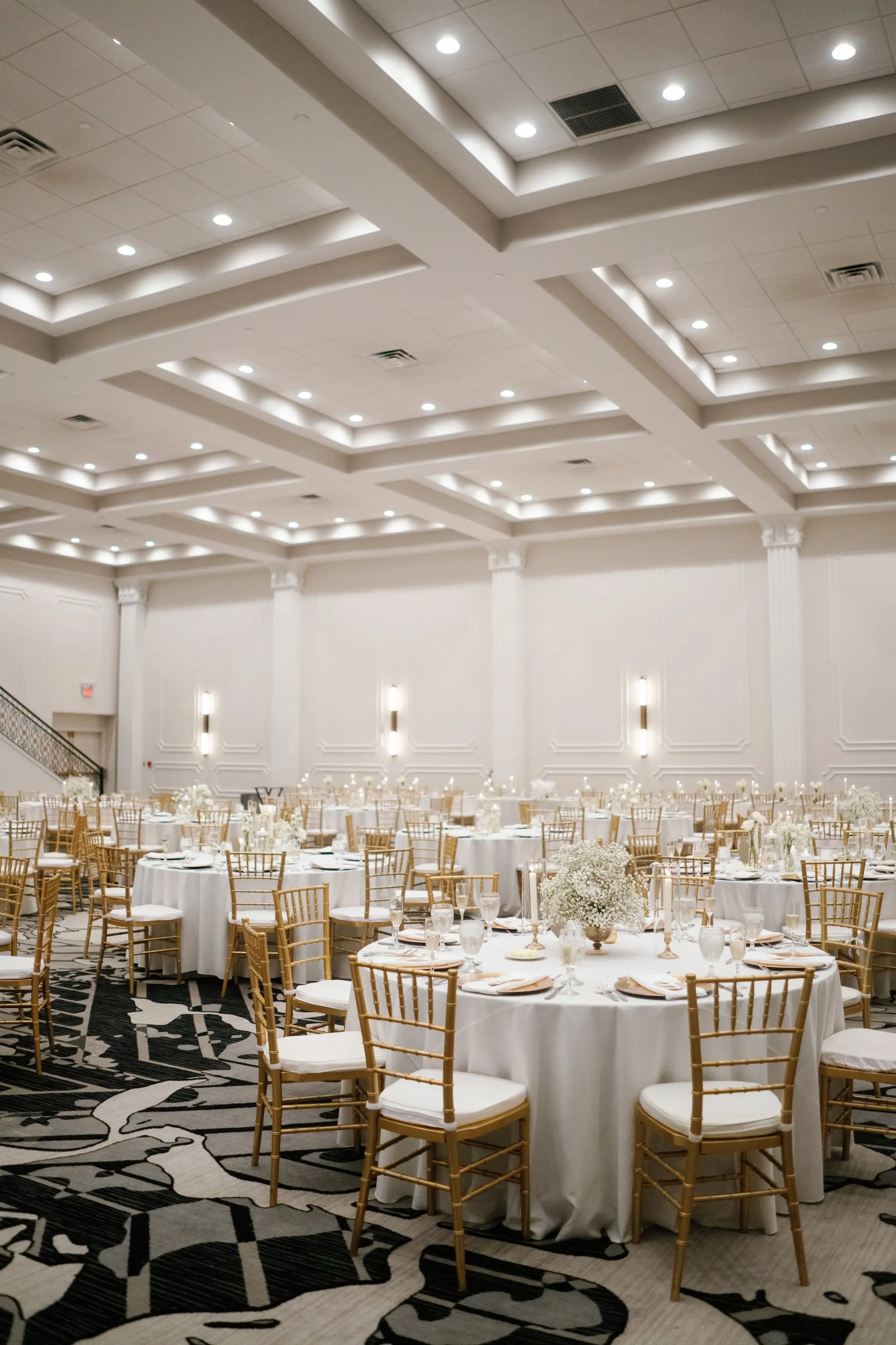 Elegant Ballroom White and Gold Wedding Reception Inspiration | Gold Chiavari Chairs at Round Tables with White Linens Decor Ideas | Gold Chargers with White Napkins and Romantic White Floral Centerpieces with Tea Candles Decor Inspiration | Historic Tampa Venue Hotel Flor