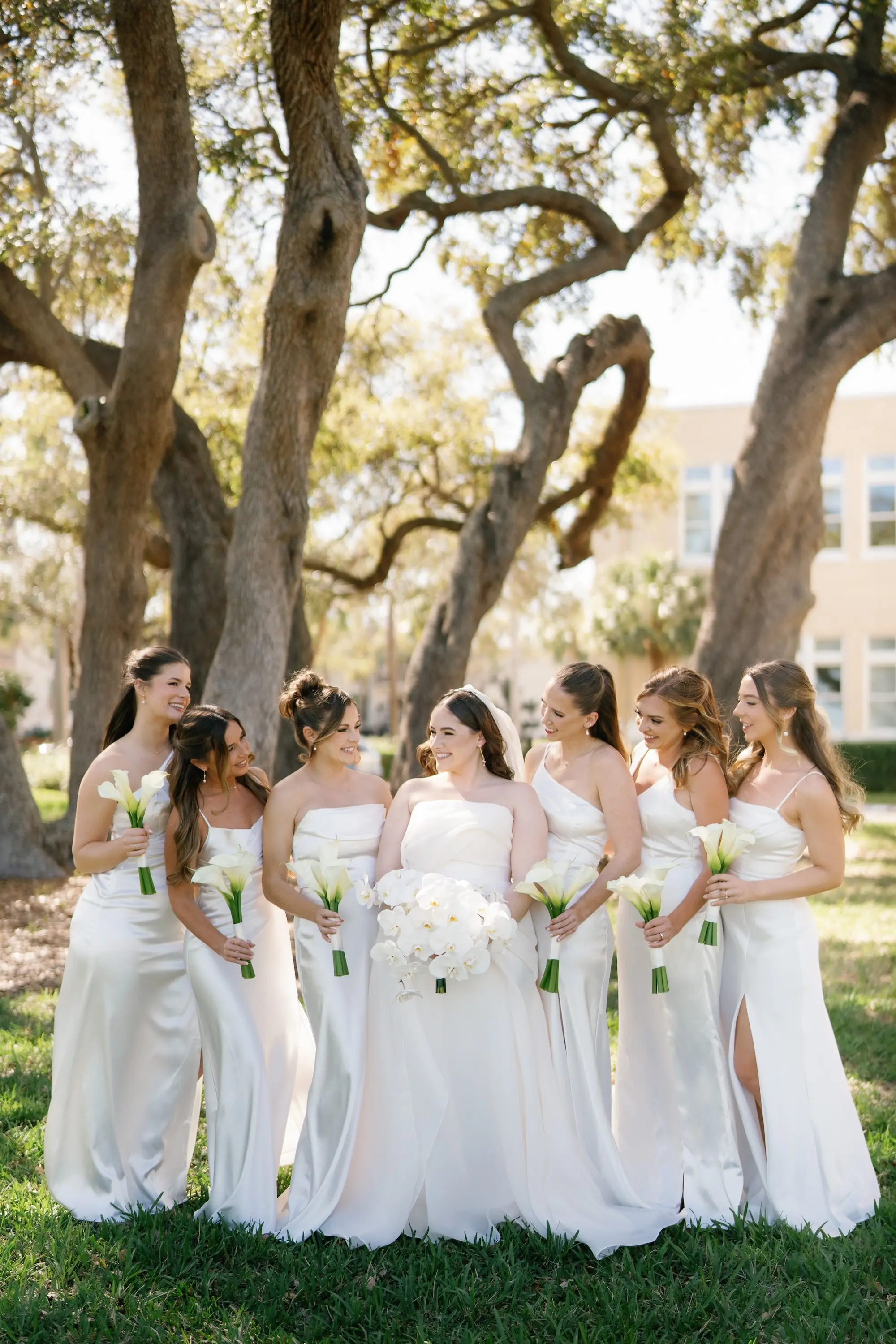 Bride and Bridesmaid Wedding Portrait | White Satin Mismatched Bridesmaid Dresses Inspiration | White Lilies with Long Stems Bouquet Ideas | White Orchid Bridal Bouquet Inspiration