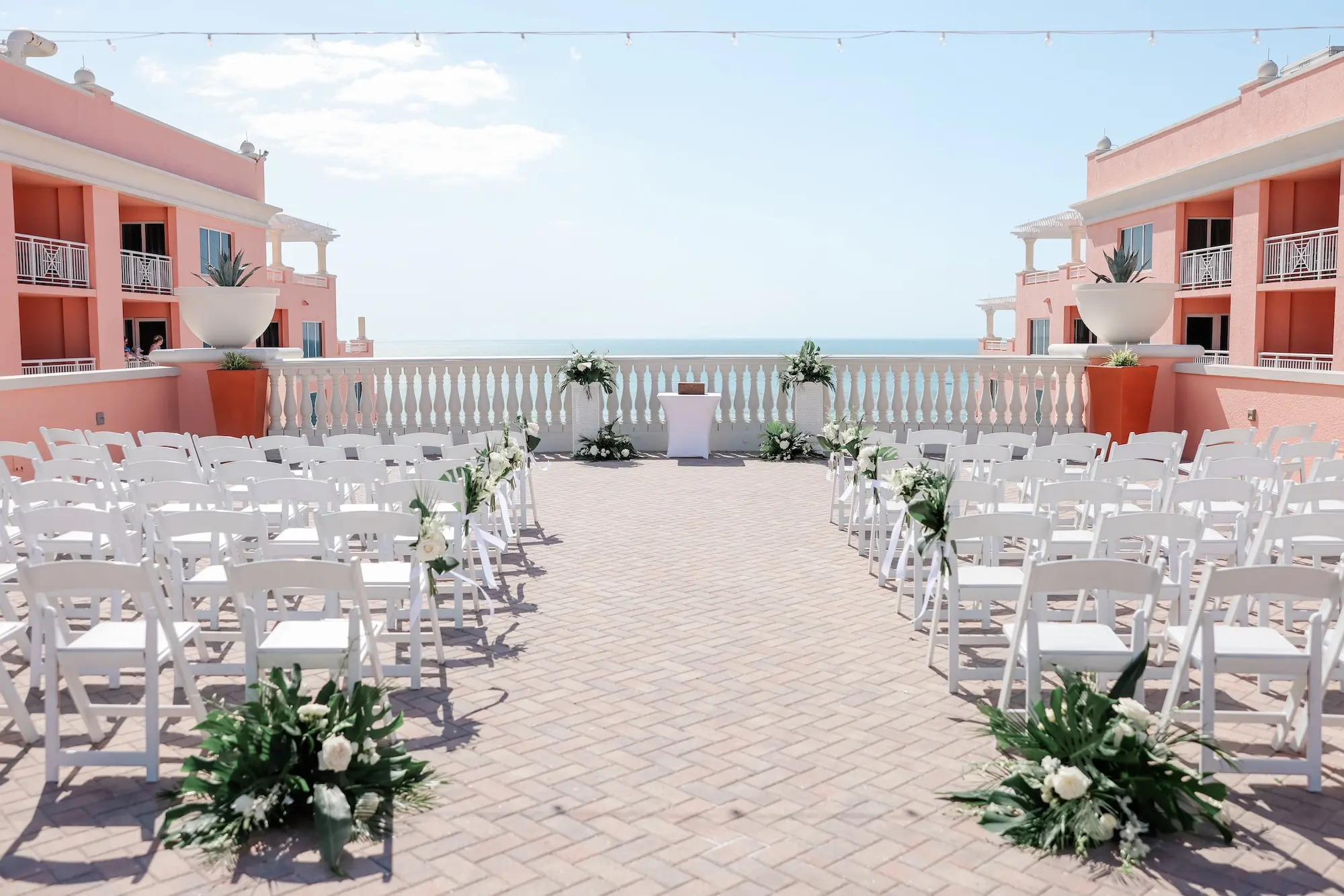 White Chairs for Intimate Rooftop Clearwater Beach Florida Wedding Ceremony Inspiration | White and Green Wedding Ceremony Aisle Altar Aisle Decor Ideas | Tampa Bay Florist Save The Date Florida | Waterfront Wedding Venue Hyatt Regency Clearwater Beach