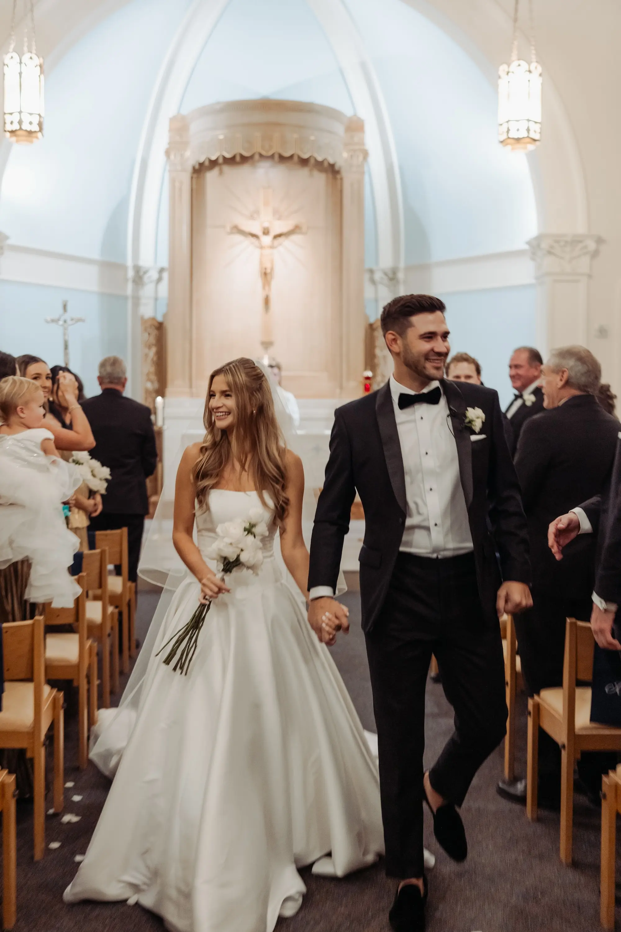 Bride and Groom Just Married Walking Down Wedding Ceremony Church Aisle Wedding Portrait | Simple Modern Long Stem White Roses Bridal Bouquet Inspiration | Live Ceremony Music Sweet Harmony Music | Traditional Catholic Church Tampa Bay Wedding Ceremony Academy of Holy Names