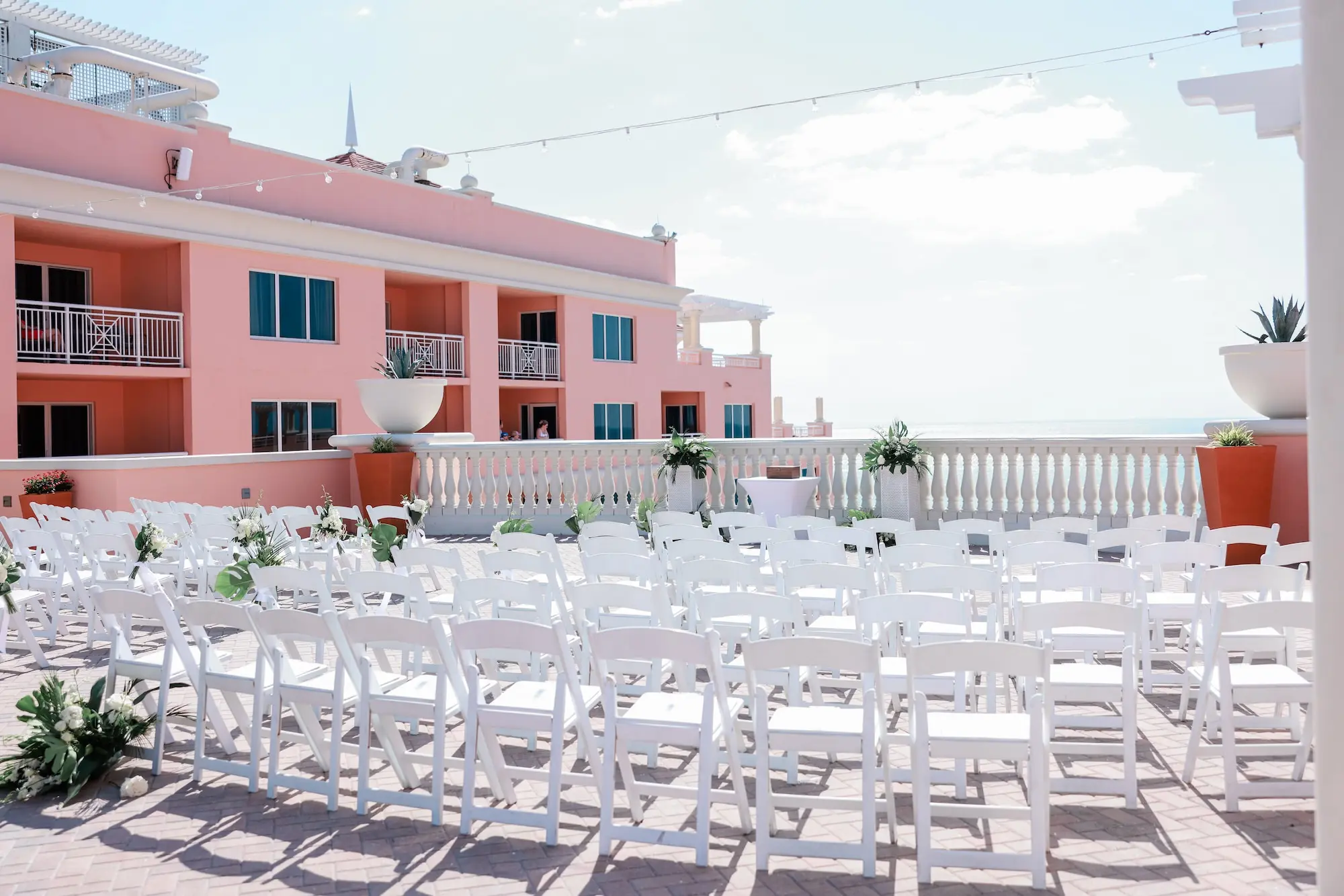 White Chairs for Intimate Rooftop Clearwater Beach Florida Wedding Ceremony Inspiration | White and Green Wedding Ceremony Aisle Altar Aisle Decor Ideas | Tampa Bay Florist Save The Date Florida | Waterfront Wedding Venue Hyatt Regency Clearwater Beach