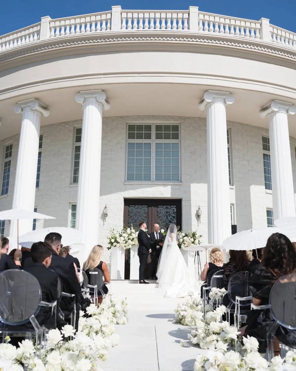 Bride and Groom Wedding Ceremony Vow Exchange Wedding | Romantic Monochromatic White Wedding Ceremony Decor Ideas | Modern White Ghost Ceremony Chairs Inspiration | Neoclassical Architectural Tarpon Springs Wedding Venue Whitehurst Gallery