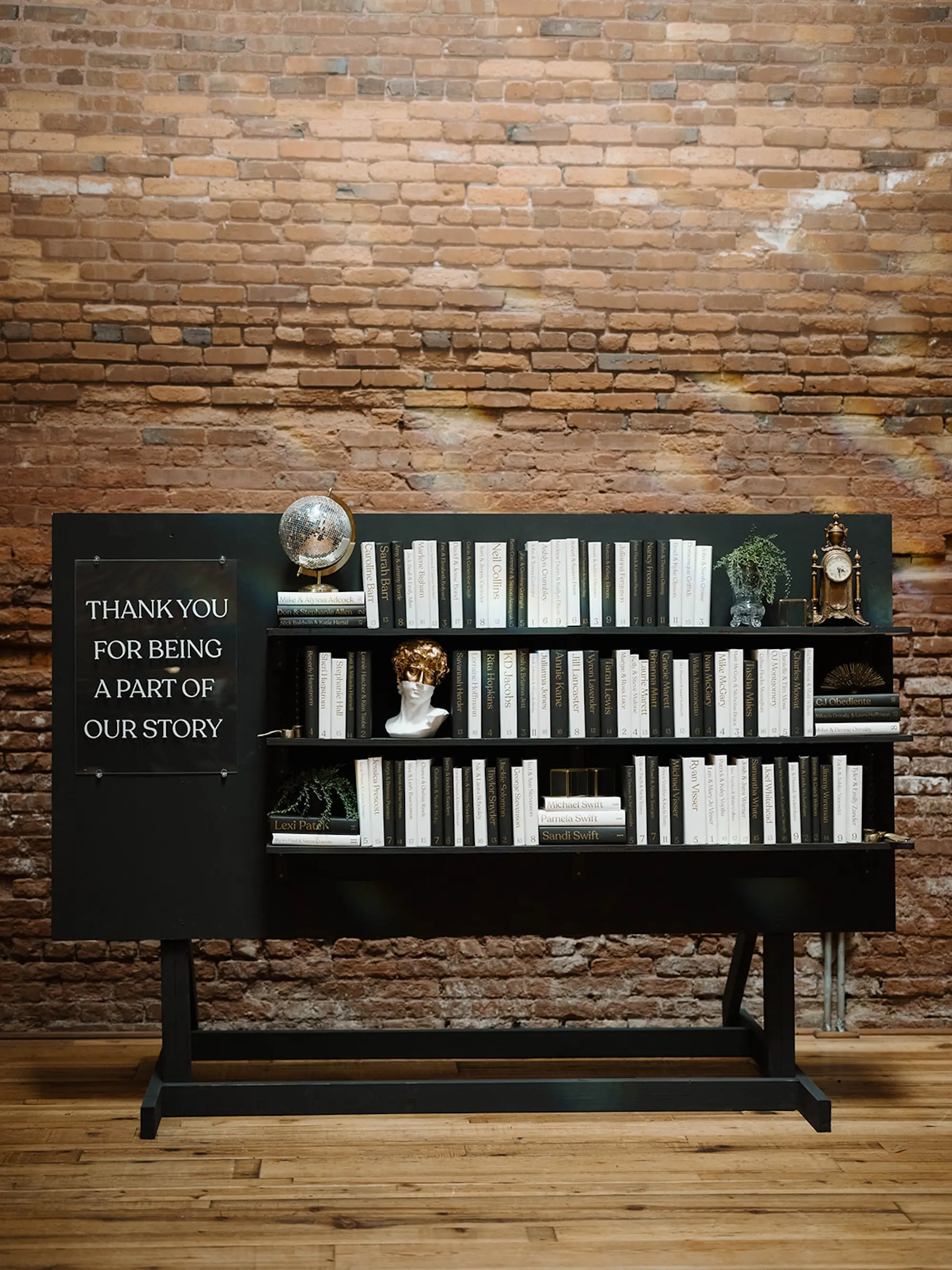 Black Book Shelf and Books Wedding Reception Seating Chart Inspiration | Exposed Brick Wedding Venue Ideas | Modern, Minimalistic Black Tie Wedding Decor Inspiration | St Pete Event Planner Coastal Coordinating