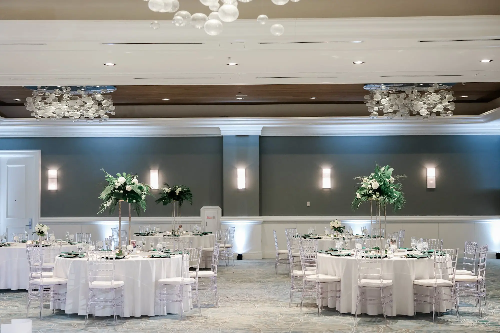 Elegant, Fresh Ballroom Wedding Reception Inspiration | White Linens with Clear Chiavari Chairs Decor Ideas | Tall Gold Vases of White and Green Botanical, Tropical Centerpieces Tablescape Decor Inspiration | Tampa Bay Florist Save The Date Florida | Florida Planner Special Moments Event Planning | Wedding Venue Hyatt Regency Clearwater Beach