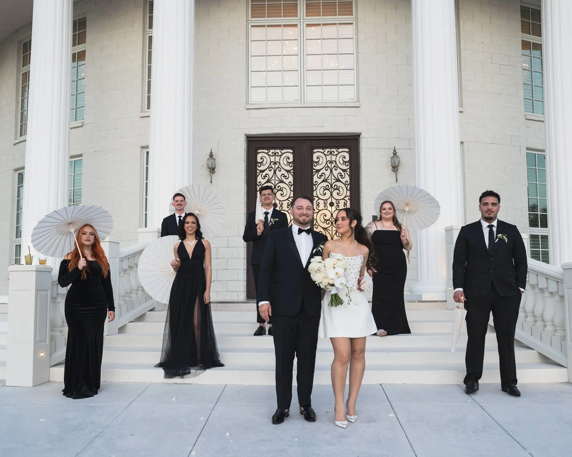 Black Tie Wedding Party Attire Ideas | Mismatched Black Bridesmaids Dress Inspiration | Traditional Black and White Groomsmen Tuxedo Ideas | White Lilies Bridal Bouquet Inspiration | Short White Ceremony Bride Dress Ideas | Tampa Bay Event Venue Whitehurst Gallery