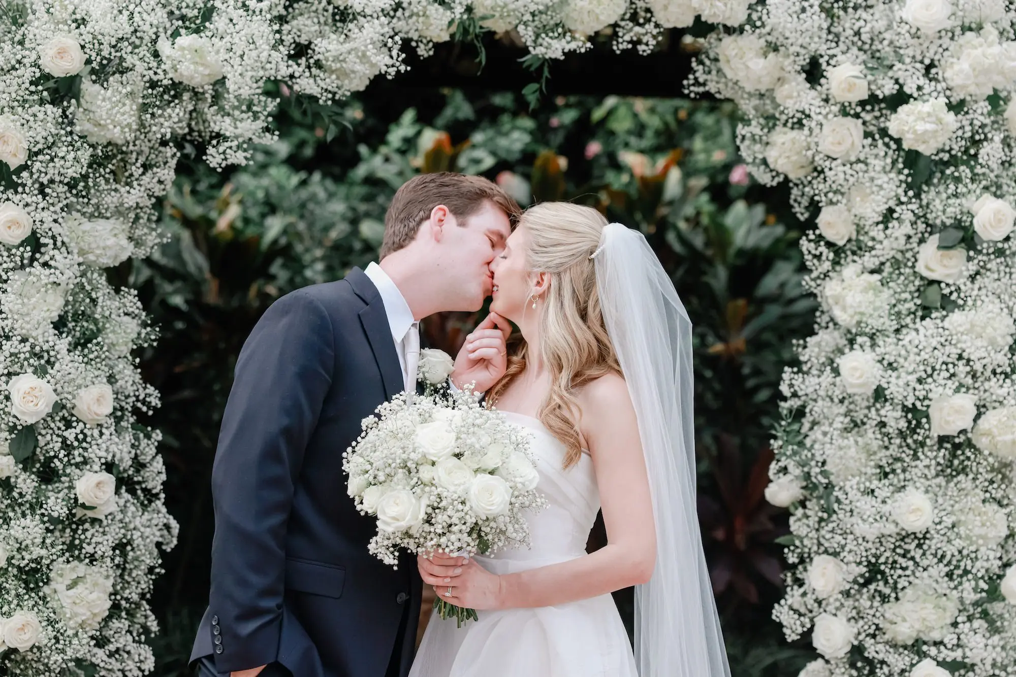 Bride and Groom Wedding Ceremony Portrait | White Roses and Baby's Breath Floral Arch Altar Decor Inspiration | Timeless White Roses Bridal Bouquet Ideas | Traditional Chiffon Veil in Half Up Half Down Soft Curls Bridal Hair Inspiration | St Pete Photographer Lifelong Photography Studio | Sarasota Hair and Makeup Artist Femme Akoi Beauty Studio