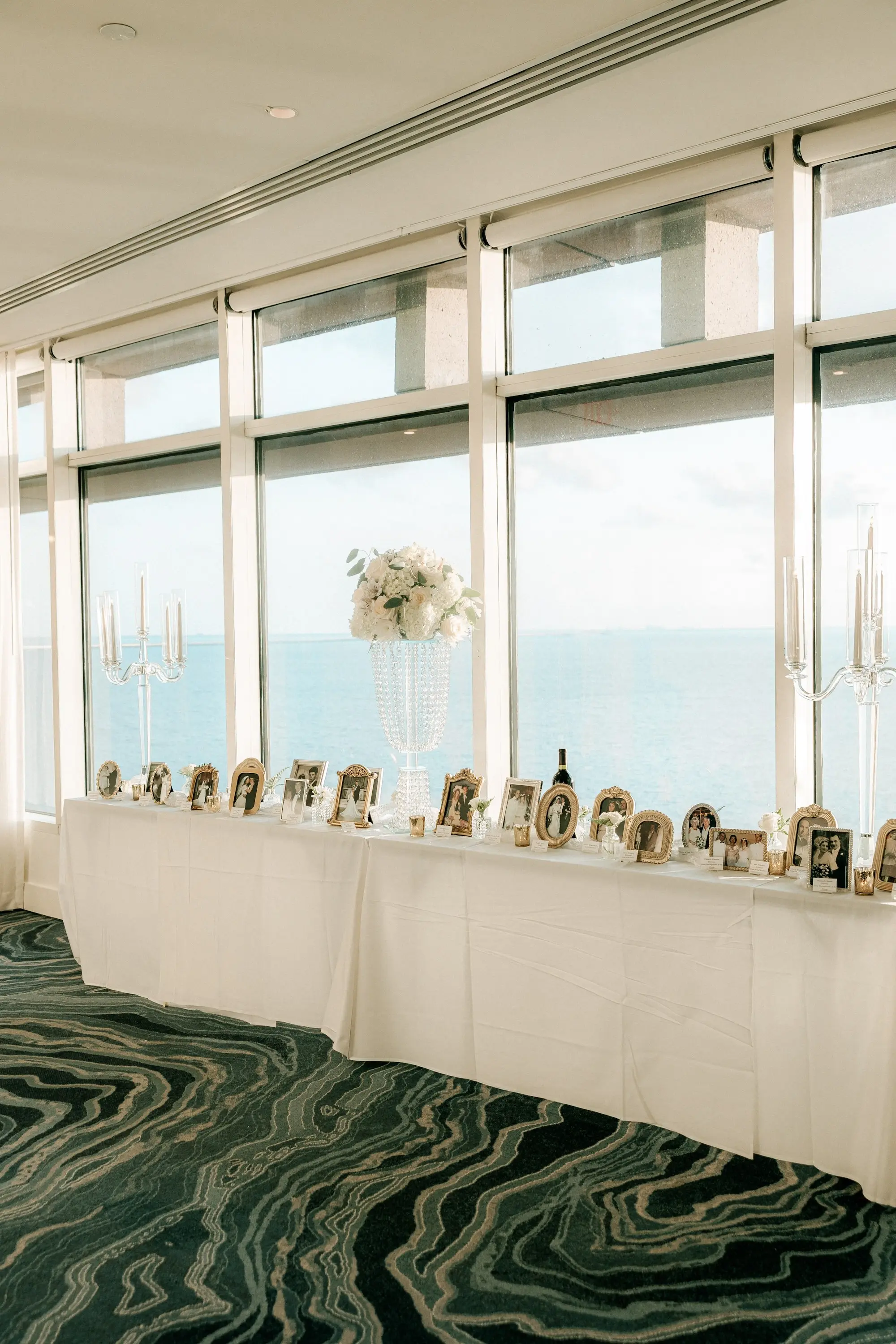20Classic Gold and White Wedding Decor Inspiration - Classic, Ivory Rooftop Wedding | Grand Hyatt Tampa Bay White Linen Long Table with Gold Frame Pictures Wedding Reception Decor Inspiration | Tall Monochromatic White Roses, Hydrangeas Floral Decor Ideas | Waterfront Wedding Reception Skylark Room Ballroom at Wedding Venue Grand Hyatt Tampa Bay