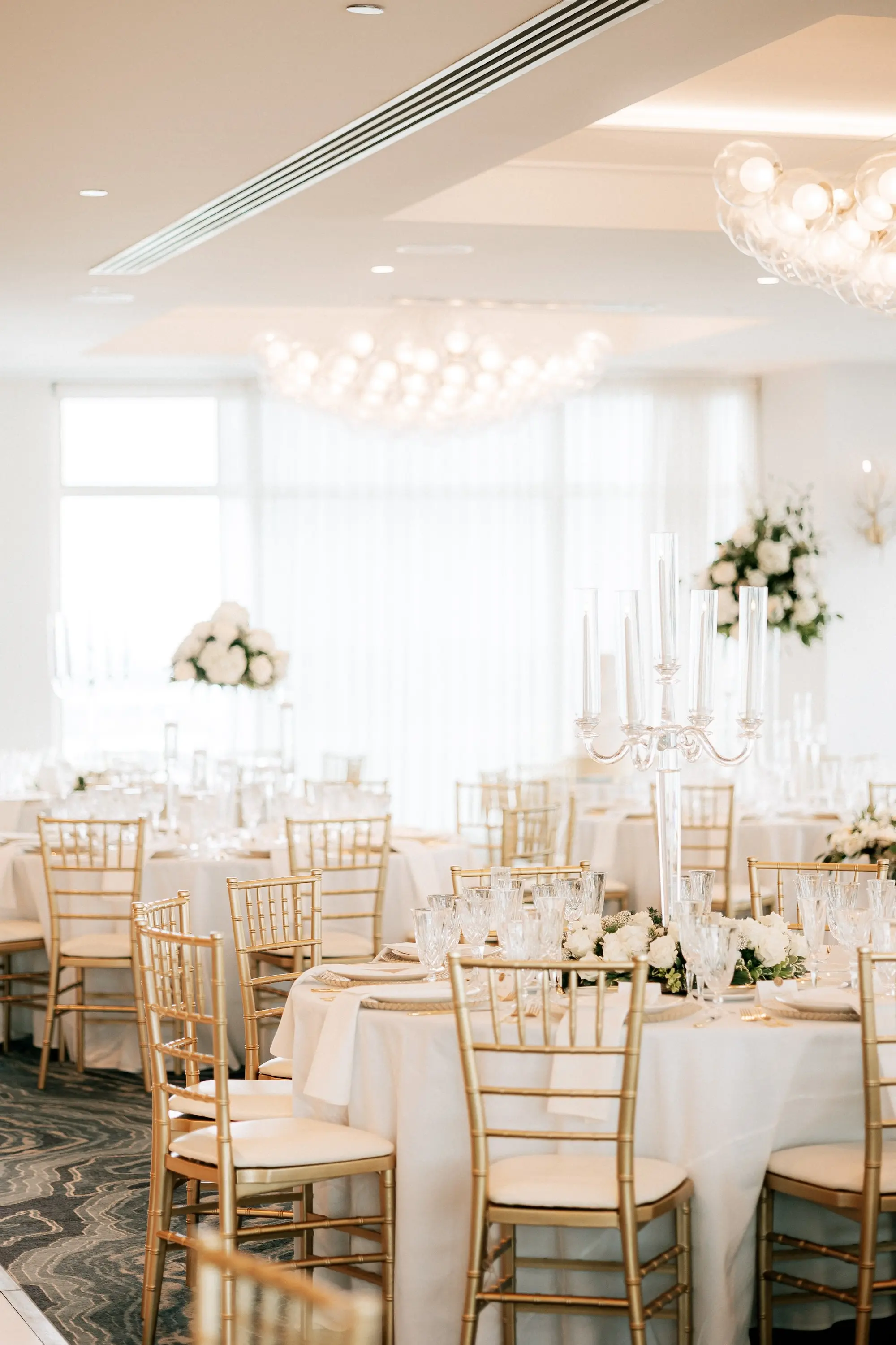 22Classic Gold and White Wedding Decor Inspiration - Classic, Ivory Rooftop Wedding | Grand Hyatt Tampa Bay Classic Gold and White Ballroom Wedding Reception Portrait | Gold Chiavari Chairs at Round White Linen Tables with Tall Monochromatic White Rose Centerpieces Decor Inspiration | Wedding Venue Grand Hyatt Tampa Bay