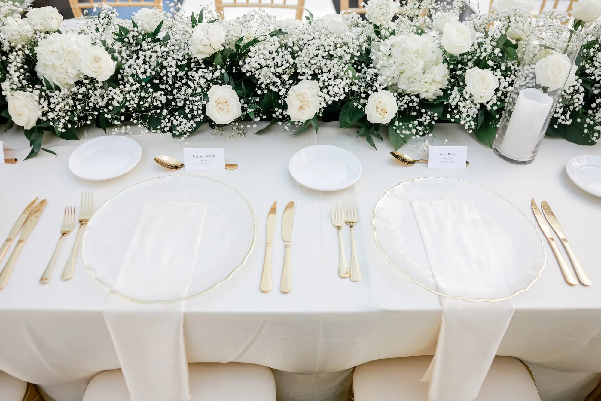 28Elegant Timeless Ivory and Green Garden Wedding - “Best Of” 2025: Wedding Receptions Part 2 Wedding Reception Table with White Linens and Clear Chargers with Gold Rims, Clear Napkins and Gold Flatware Ideas | White Roses and Baby's Breath Wedding Reception Decor Centerpiece Garland Inspiration | Tampa Bay Rentals Fiesta Solutions Event Rentals | Caterer Amici's Catered Cuisine