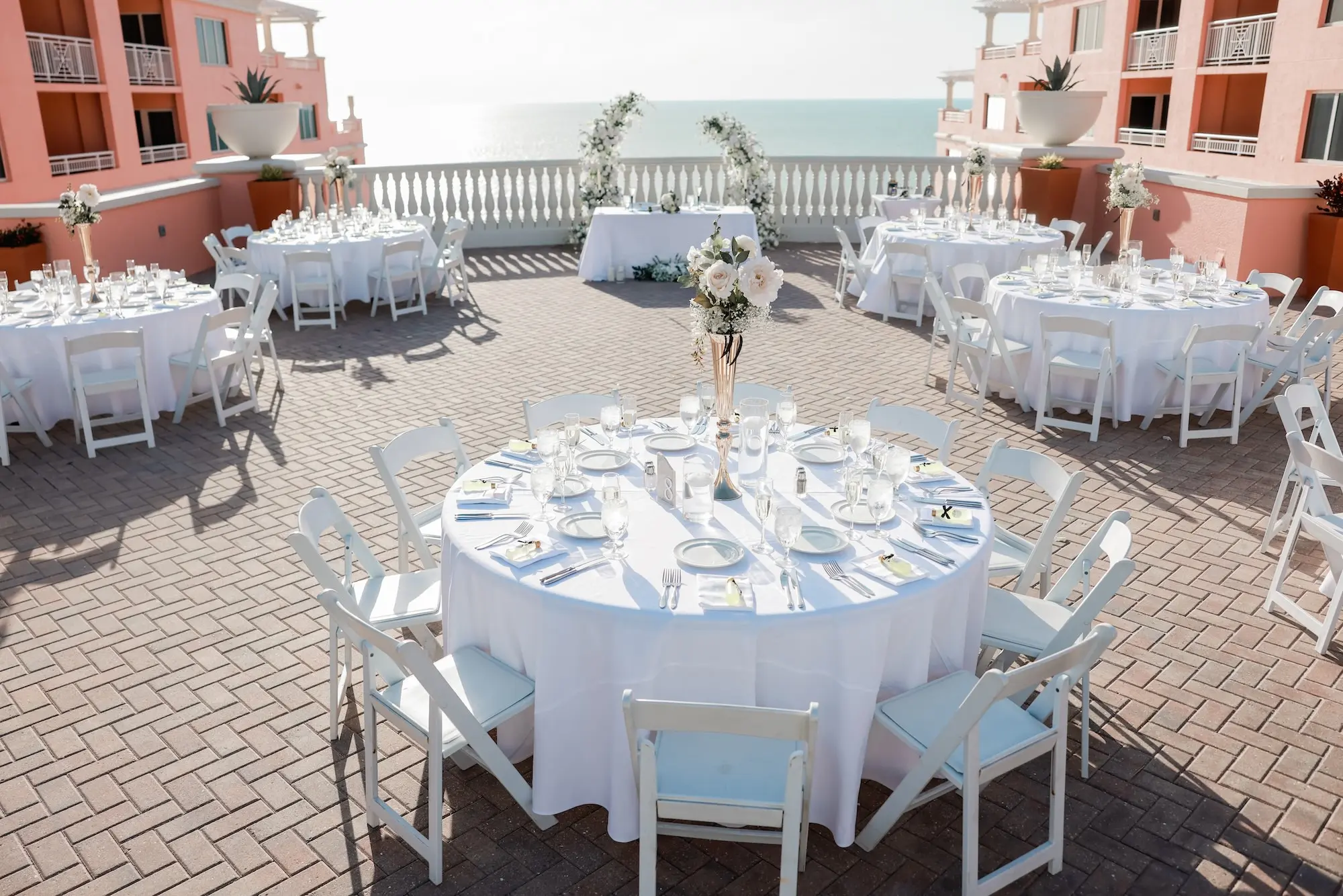 Elegant White Monochromatic Rooftop Terrace Wedding Reception Inspiration | Round Tables with White Linens and White Chairs Table Decor Ideas | Waterfront Wedding Venue Hyatt Regency Clearwater Beach