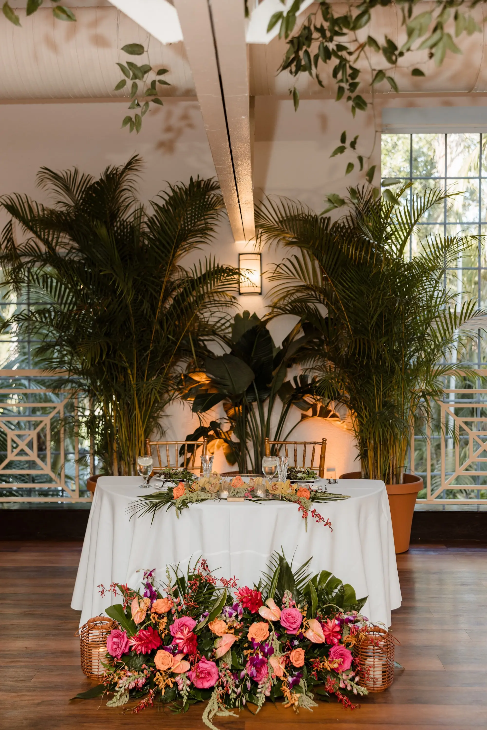 Tropical Spring Ballroom Wedding Reception Sweetheart Table Decor Inspiration | Red Gingers, Birds of Paradise Monstera Leaf, Palm Leaf, and Fern Greenery Arrangement Wedding Reception Decor Ideas | Florist Save The Date Florida | Tampa Bay Photographer Evoke Photo and Film