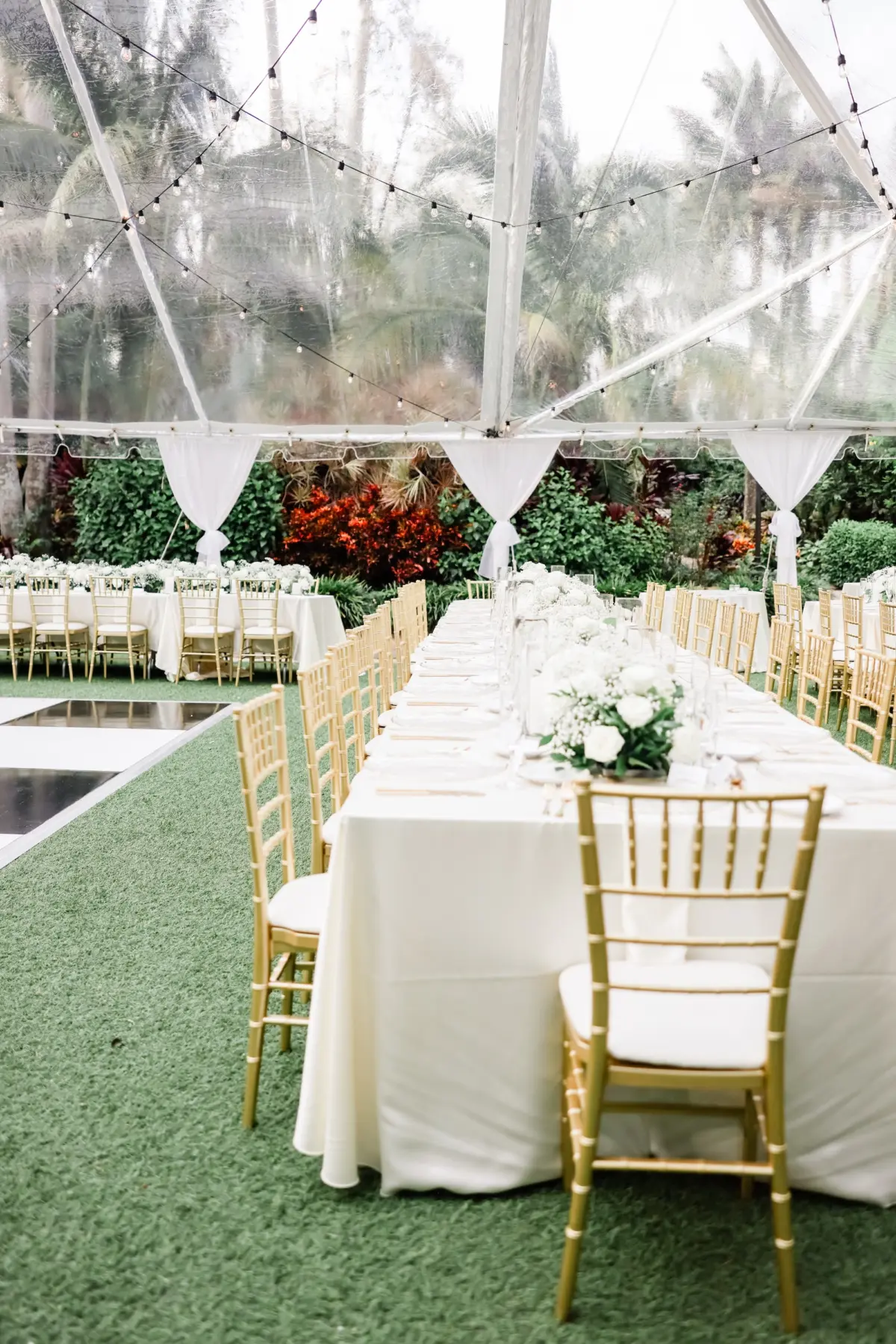 33Elegant Timeless Ivory and Green Garden Wedding - Romantic Outdoor St. Pete Wedding | Sunken Gardens Outdoor Tented Wedding Reception Ideas | Long Reception Table with White Linens and Gold Chiavari Chairs Inspiration | Clear Chargers with Gold Rims and Gold Flatware Ideas | White Roses and Baby's Breath Wedding Reception Decor Centerpiece Garland Inspiration | Tampa Bay Rentals Fiesta Solutions Event Rentals | St Pete Venue Sunken Gardens