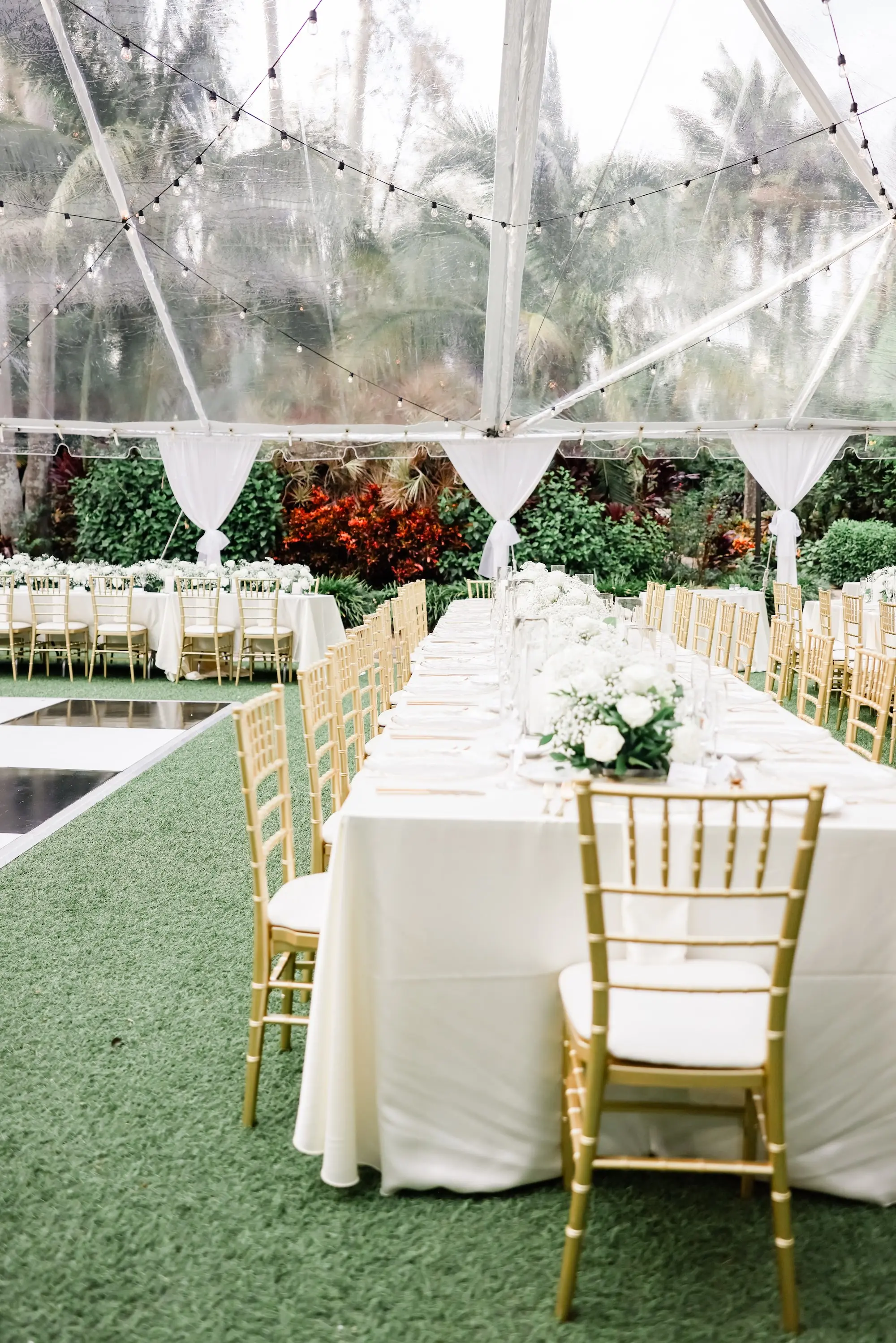 33Elegant Timeless Ivory and Green Garden Wedding - Romantic Outdoor St. Pete Wedding | Sunken Gardens Outdoor Tented Wedding Reception Ideas | Long Reception Table with White Linens and Gold Chiavari Chairs Inspiration | Clear Chargers with Gold Rims and Gold Flatware Ideas | White Roses and Baby's Breath Wedding Reception Decor Centerpiece Garland Inspiration | Tampa Bay Rentals Fiesta Solutions Event Rentals | St Pete Venue Sunken Gardens