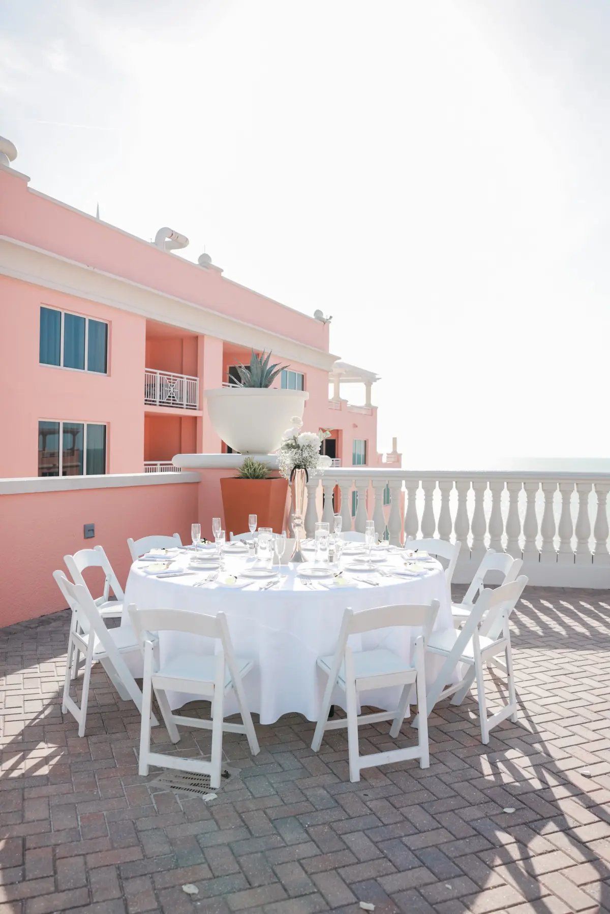 Elegant White Monochromatic Rooftop Terrace Wedding Reception Inspiration | Round Tables with White Linens and White Chairs Table Decor Ideas | Waterfront Wedding Venue Hyatt Regency Clearwater Beach