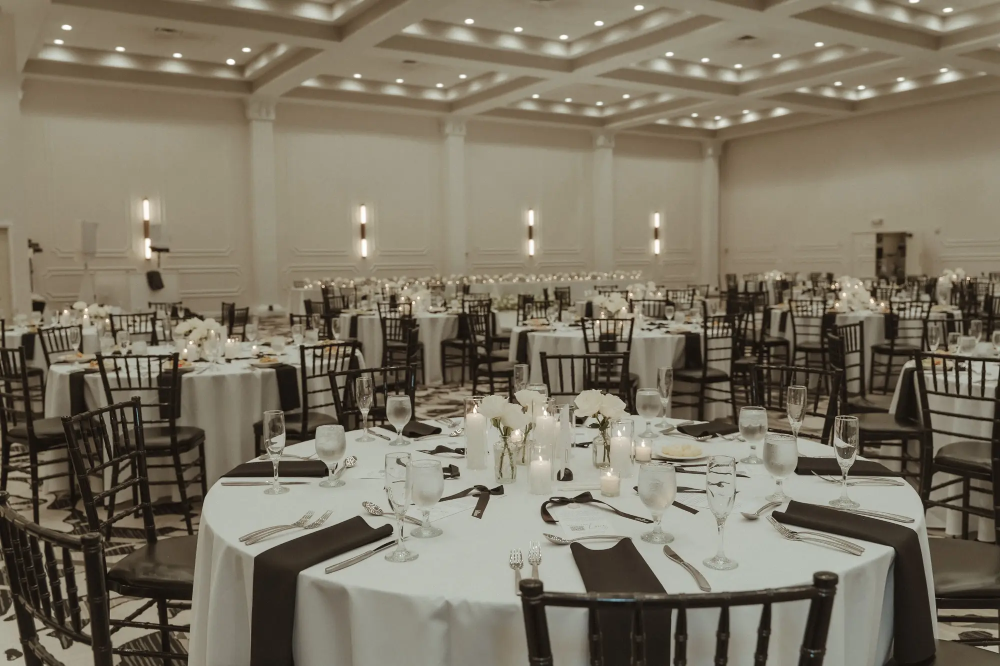 33Sophiscated Black and White Wedding Inspiration Tampa Venue Hotel Flor - “Best Of” 2025: Wedding Receptions Part 2 Sophisticated Black and White Wedding Reception Decor Ideas | White Table Linens with Black Napkins and Black Chiavari Chairs Wedding Reception Decor Inspiration | Romantic Candles and Single Stem White Roses in Bud Vases Centerpiece Decor Ideas | Historic Tampa Venue Hotel Flor | Tampa Bay Planner The Olive Tree Weddings