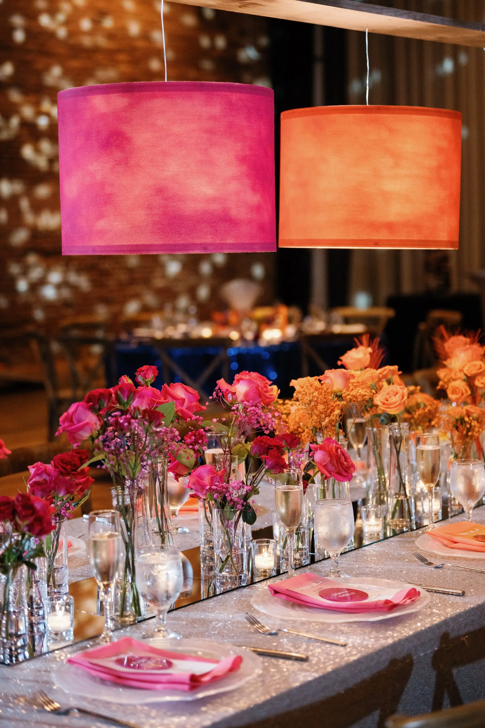 33Whimsical Rainbow Inspired Wedding Ideas - “Best Of” 2025: Wedding Receptions Part 2 Bright Colorful Rainbow Wedding Reception Long Table Decor Inspiration | Silver Sequined Table Cloth Ideas | Pink and Orange Flower Centerpiece Bud Vase Arrangement Decor Inspiration | Bold Pink and Orange Lighting Lamp Table Decor Ideas | Tabletop Rentals A Chair Affair | Different Color Napkins on Clear Chargers Tablescape Inspiration | Over The Top Rental Linens | Event Planner Unique Weddings and Events