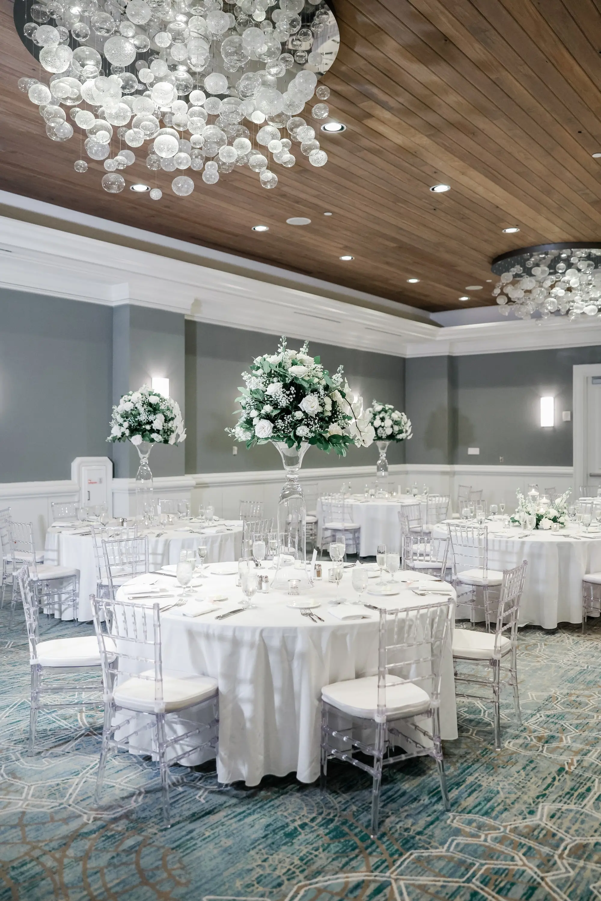 48Classic White Florida Wedding Ideas Venue Hyatt Clearwater Beach - Classic, White Rooftop Wedding | Hyatt Regency Clearwater Beach Luxurious Monochromatic White Ballroom Wedding Reception | Modern Clear Chiavari Chairs | Tall Glass Centerpieces with White, Roses and Greenery Flower Arrangement Ideas | Tampa Bay Planner Planner Coastal Coordinating | St Pete Rentals Gabro Event Services | Wedding Venue Hyatt Regency Clearwater Beach Resort and Spa