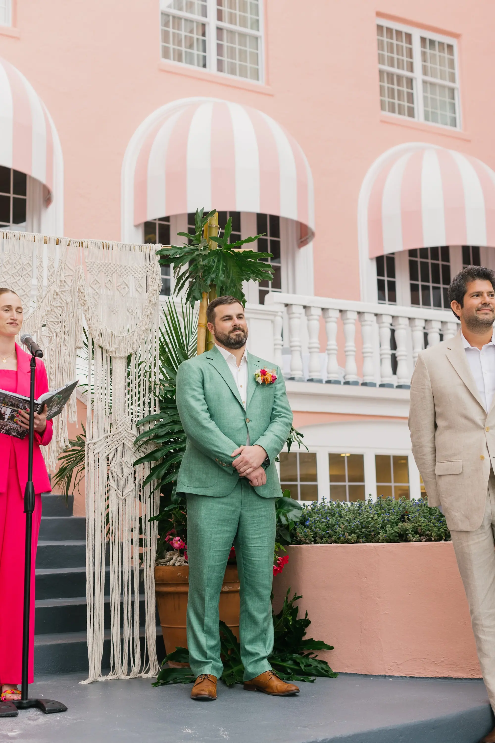 21Tropical Beach Boho Pink and Orange Wedding Inspiration - Vibrant, Tropical Boho St. Pete Beach Wedding | The Don CeSar Groom's Reaction to Bride Walking Down Wedding Ceremony Aisle | Boho Beach Wedding Ceremony Decor Inspiration | Groom's Sage Green Linen Wedding Suit Attire Ideas | Macrame Wedding Ceremony Altar Decor Inspiration | Tampa Bay Planner EventFull Weddings