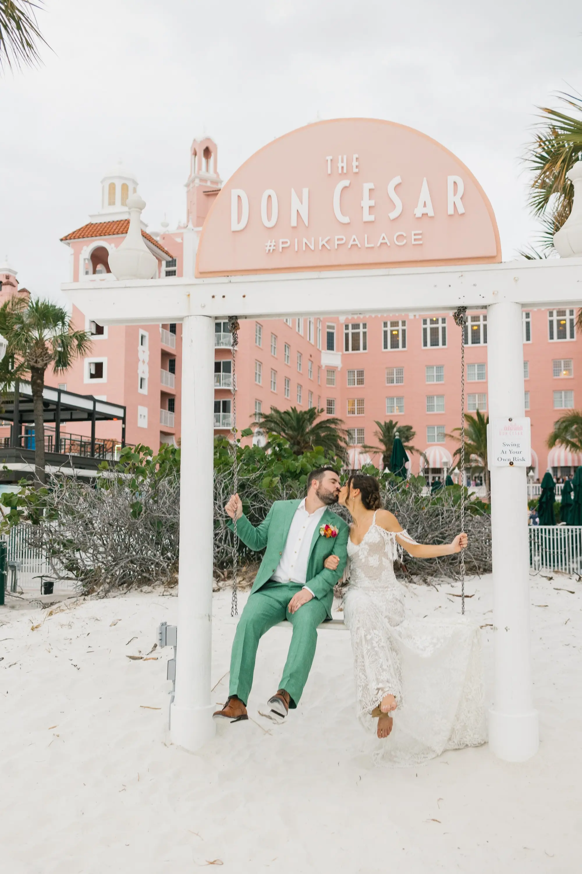 31Tropical Beach Boho Pink and Orange Wedding Inspiration St Pete Venue The Don CeSar - Vibrant, Tropical Boho St. Pete Beach Wedding | The Don CeSar Bride and Groom Kissing on Beach Swing Wedding Portrait | Historic Pink Palace St Pete Beach Wedding Venue Don CeSar | St Pete Beach Resort Wedding Venue