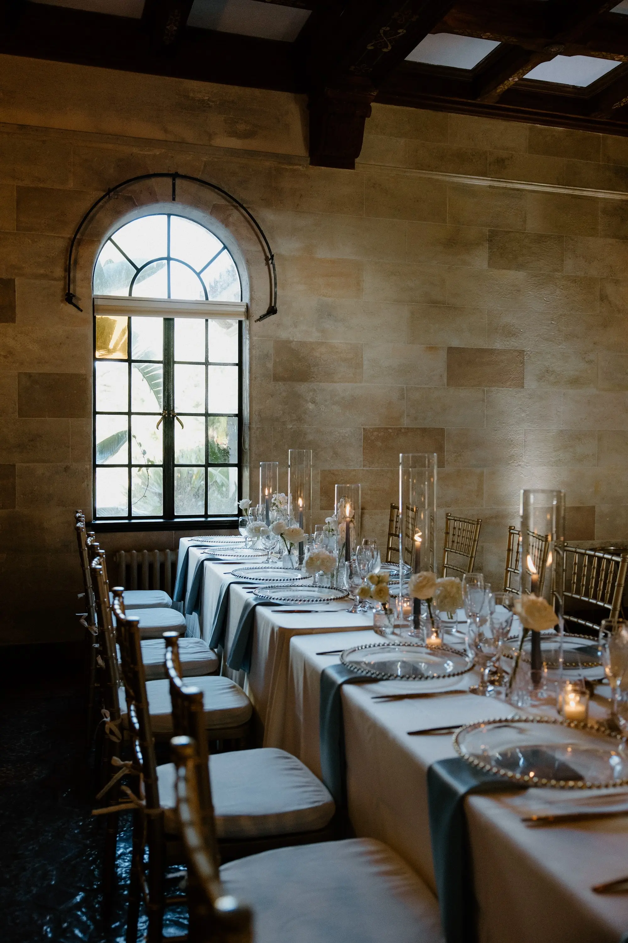 Classic Ballroom Wedding Reception | Bud Vase Centerpiece White Roses and Orchid Flower Arrangement Ideas | Gold Chiavari Reception Chairs | Blue Taper Candles in Glass Vases Wedding Reception Tablescape Decor Inspiration | Clear Chargers with Gold Rims on Blue Satin Napkins Reception Decor Ideas | Sarasota Florist Beneva Flowers