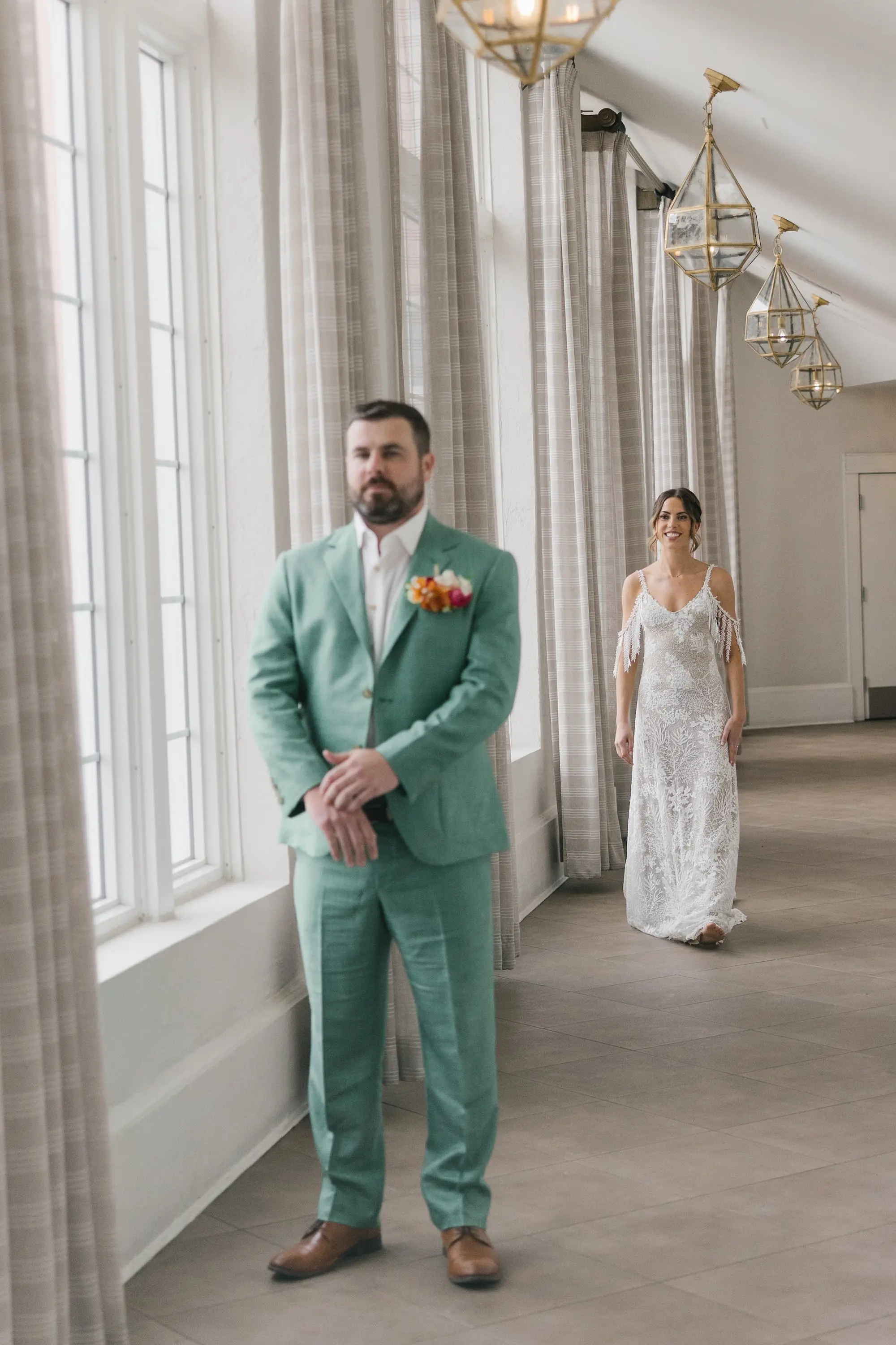 3Tropical Beach Boho Pink and Orange Wedding Inspiration - Vibrant, Tropical Boho St. Pete Beach Wedding | The Don CeSar Bride and Groom First Look Wedding Portrait | Groom's Sage Green Linen Wedding Suit Attire Ideas | Low Bun with Loose Curls Boho Wedding Hairstyle Inspiration | Romantic Bohemian Grace Loves Lace Wedding Gown with Detailed Floral Lace and Off-the-Shoulder Tasseled Armbands Ideas | Tampa Bay Hair and Makeup Artist Femme Akoi Beauty Studio