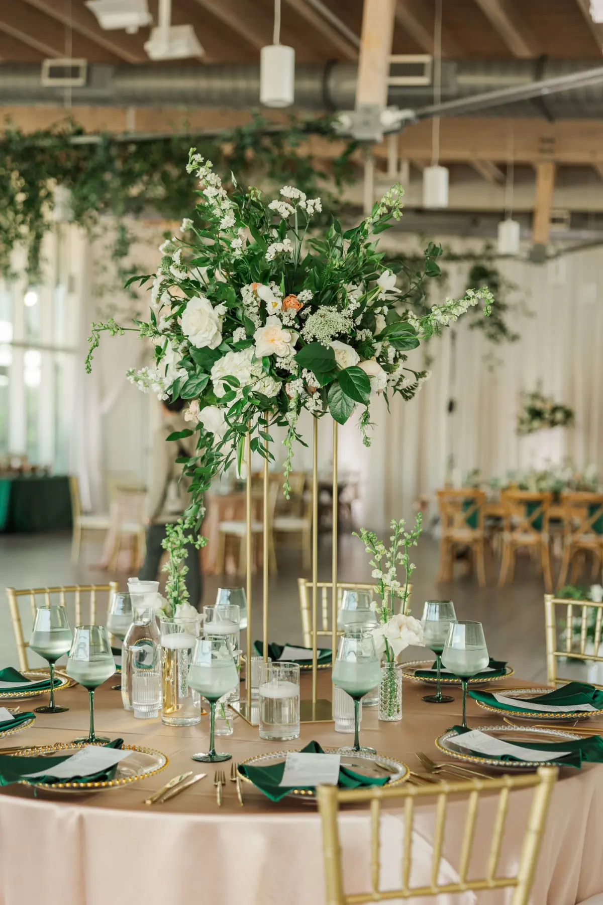 41Classic Emerald Green and Champagne Wedding Inspiration - Classic Emerald Green Downtown Tampa Wedding | Bob Buckhorn Center Luxurious Riverfront Ballroom Wedding Reception | Gold Chiavari Chairs | Tall Gold Platform Centerpieces with White Hydrangeas, Roses, Wisteria Flower and Palm Greenery Arrangement Ideas | Clear Chargers with Gold Scalloped Edges and Emerald Green Napkins Tablescape Decor Inspiration | Tampa Bay Planner Wilder Mind Events | Florida Elite Events Catering | Venue Tampa River Center