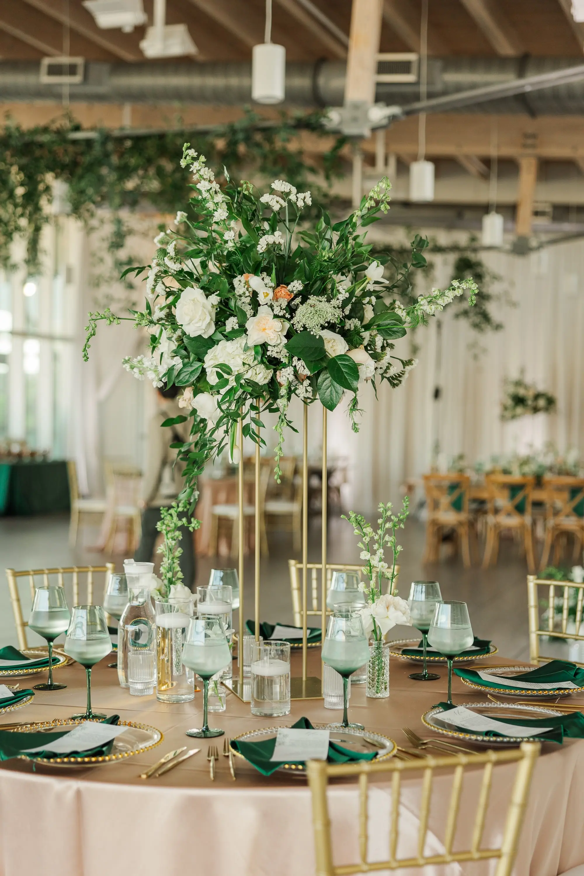 41Classic Emerald Green and Champagne Wedding Inspiration - Classic Emerald Green Downtown Tampa Wedding | Bob Buckhorn Center Luxurious Riverfront Ballroom Wedding Reception | Gold Chiavari Chairs | Tall Gold Platform Centerpieces with White Hydrangeas, Roses, Wisteria Flower and Palm Greenery Arrangement Ideas | Clear Chargers with Gold Scalloped Edges and Emerald Green Napkins Tablescape Decor Inspiration | Tampa Bay Planner Wilder Mind Events | Florida Elite Events Catering | Venue Tampa River Center