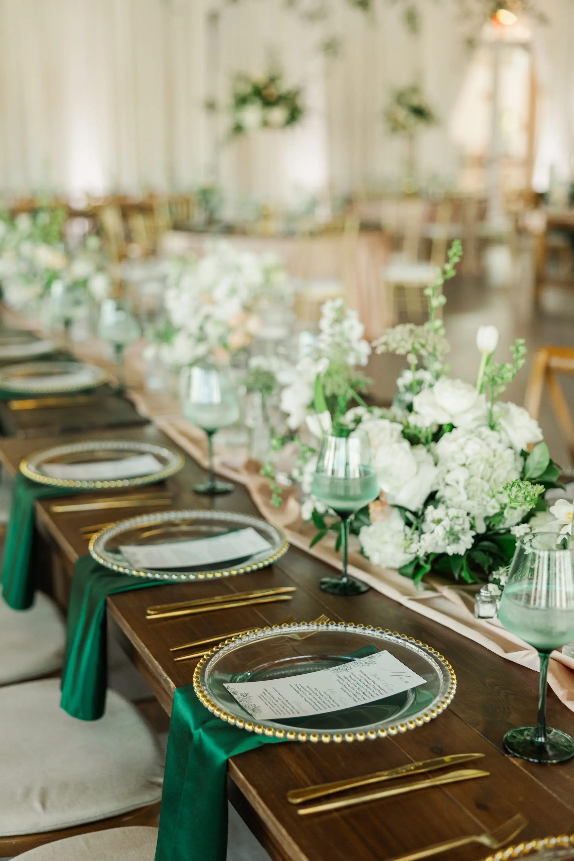 43Classic Emerald Green and Champagne Wedding Inspiration - Classic Emerald Green Downtown Tampa Wedding | Bob Buckhorn Center Romantic Riverfront Ballroom Wedding Reception | Gold Chiavari Chairs | Tall Gold Platform Centerpieces with White Hydrangeas, Roses, Wisteria Flower and Palm Greenery Arrangement Ideas | Clear Chargers with Gold Scalloped Edges and Emerald Green Napkins Tablescape Decor Inspiration | Tampa Bay Planner Wilder Mind Events | Florida Elite Events Catering