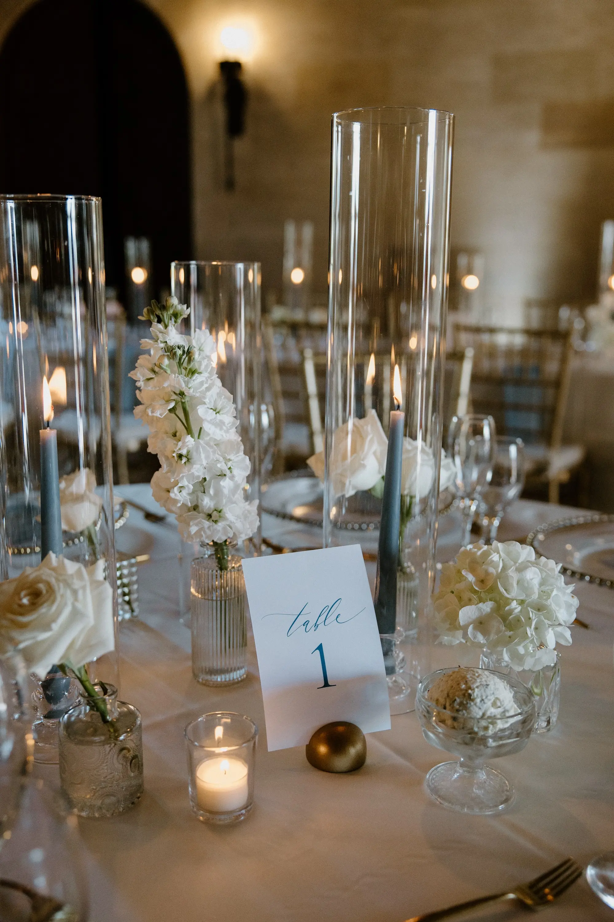 Classic Ballroom Wedding Reception | Bud Vase Centerpiece White Roses and Orchid Flower Arrangement Ideas | Blue Taper Candles in Glass Vases Wedding Reception Tablescape Decor Inspiration | White Cardstock with Blue Writing Table Number Ideas | Sarasota Florist Beneva Flowers