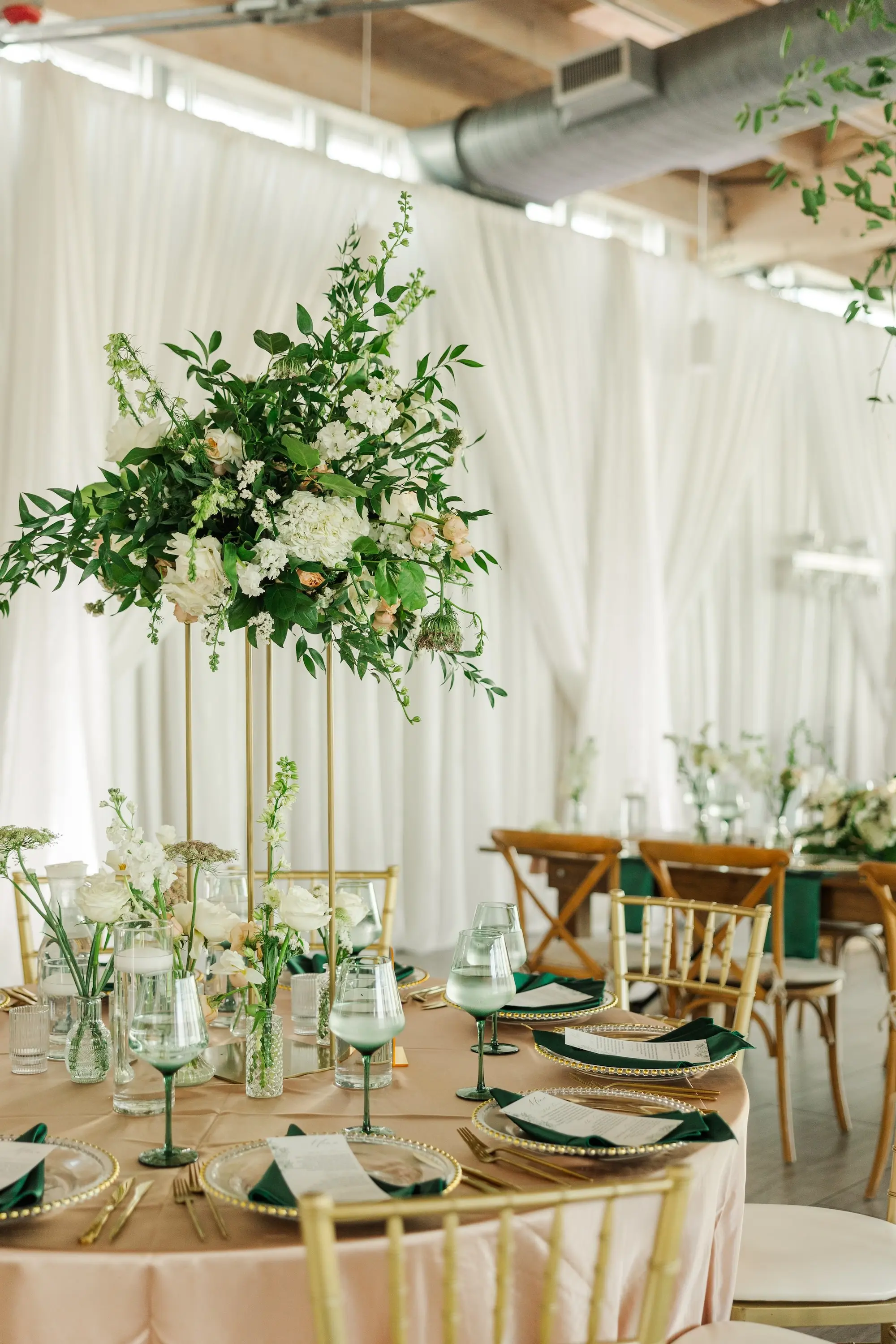 45Classic Emerald Green and Champagne Wedding Inspiration - Classic Emerald Green Downtown Tampa Wedding | Bob Buckhorn Center Luxurious Riverfront Ballroom Wedding Reception | Gold Chiavari Chairs | Tall Gold Platform Centerpieces with White Hydrangeas, Roses, Wisteria Flower and Palm Greenery Arrangement Ideas | Clear Chargers with Gold Scalloped Edges and Emerald Green Napkins Tablescape Decor Inspiration | Tampa Bay Planner Wilder Mind Events | Florida Elite Events Catering | Venue Tampa River Center