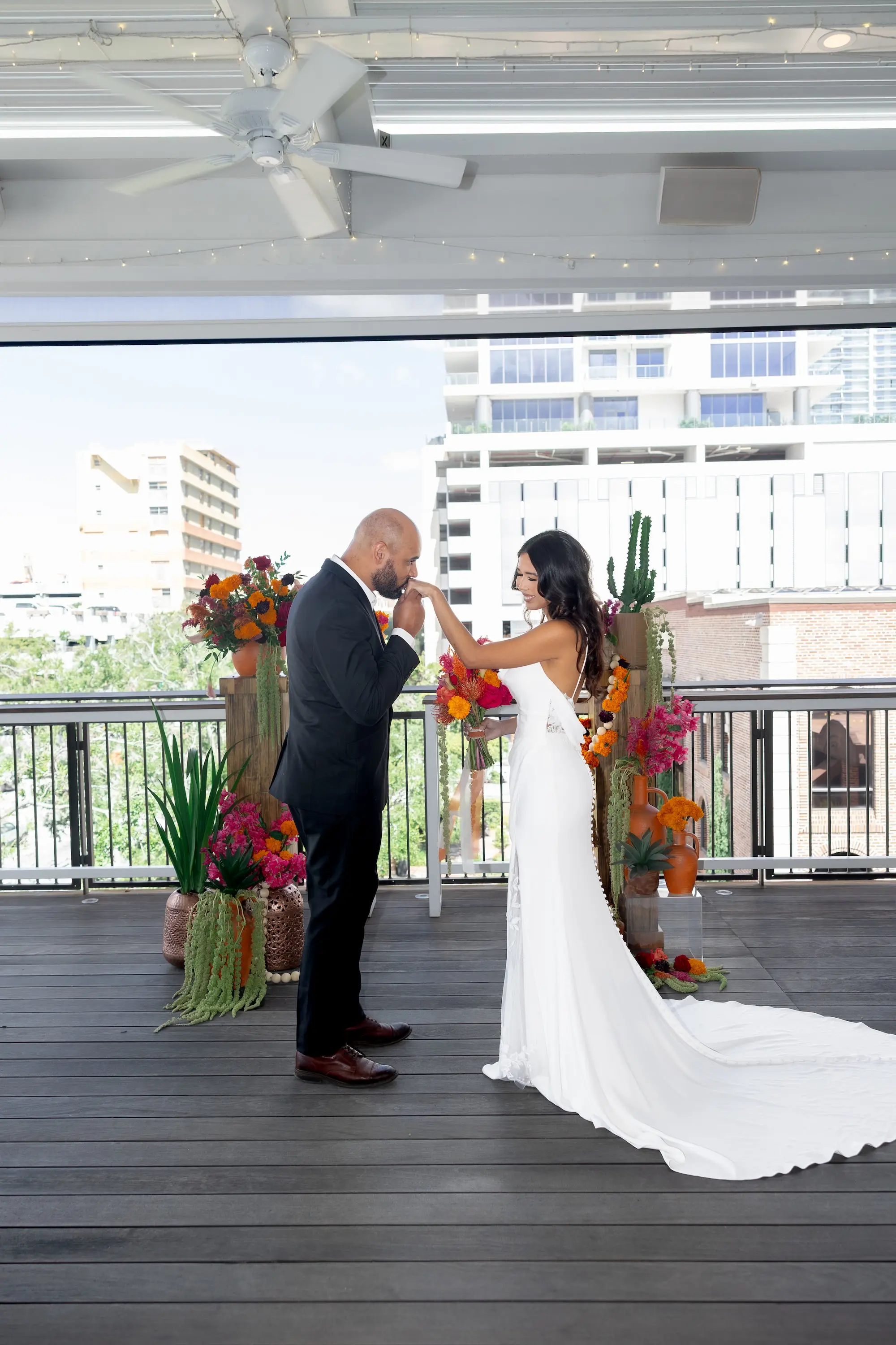 17Vibrant Southwestern Terracotta Pink and Orange Wedding Ideas St Pete Venue Red Mesa Events - Vibrant, Rooftop Wedding Inspiration Shoot | Red Mesa Events Bride and Groom at Altar Wedding Portrait | Vibrant Southwest Mexican Wedding Reception Ideas | Bright Pink and Orange Floral Arrangements on Rustic Wooden Columns with Lush Green Succulents and Cacti Greenery Arrangement Reception Decoration Inspiration | Terracotta Pots Decor Ideas | Tampa Bay Florist Save The Date Florida | St Pete Event Planner Coastal Coordinating | Soft Curled Hair with Natural Glam Makeup Inspiration | Tampa Bay Photographer Pine and Forge Photography | Downtown St Pete Event Venue Red Mesa Events | Tampa Bay Boutique Truly Forever Bridal | Sarasota Hair and Makeup Artist Femme Akoi Beauty Studio