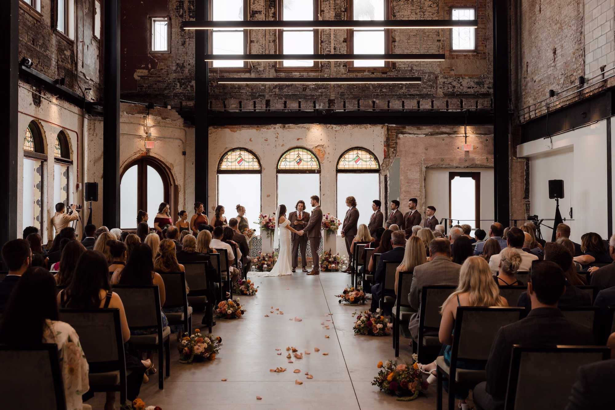 Bride and Groom Wedding Ceremony Vow Exchange Wedding Portrait | Historic Wedding Ceremony with Arched Stained Glass Windows Ideas | Fall Color Florals of Deep Red, Orange, Blush and Purple Wedding Ceremony Altar Decor Inspiration | Las Novedades Wedding Ceremony Ybor City Venue at Hotel Haya | Tampa Bay Photographer Evoke Photo and Film