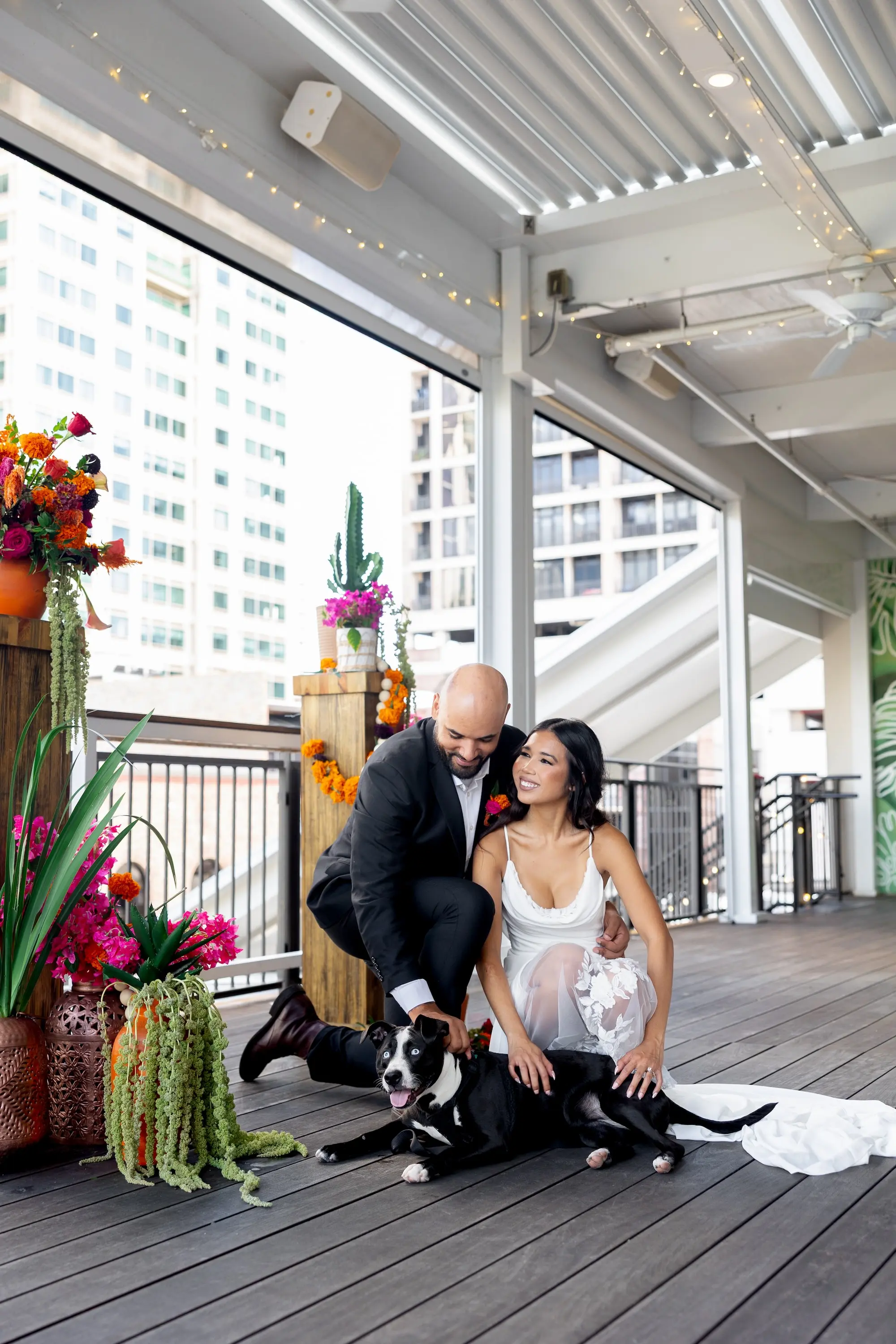 25Vibrant Southwestern Terracotta Pink and Orange Wedding Ideas - Vibrant, Rooftop Wedding Inspiration Shoot | Red Mesa Events Bride and Groom with Pet Wedding Portrait | Vibrant Southwest Mexican Wedding Reception Ideas | Bright Pink and Orange Floral Arrangements on Rustic Wooden Columns with Lush Green Succulents and Cacti Greenery Arrangement Reception Decoration Inspiration | Terracotta Pots Decor Ideas | Tampa Bay Florist Save The Date Florida | St Pete Event Planner Coastal Coordinating | Soft Curled Hair with Natural Glam Makeup Inspiration | Tampa Bay Photographer Pine and Forge Photography | Downtown St Pete Event Venue Red Mesa Events | Tampa Bay Boutique Truly Forever Bridal | Sarasota Hair and Makeup Artist Femme Akoi Beauty Studio | Content Creator Behind The Vows | Tampa Bay FairyTail Pet Care