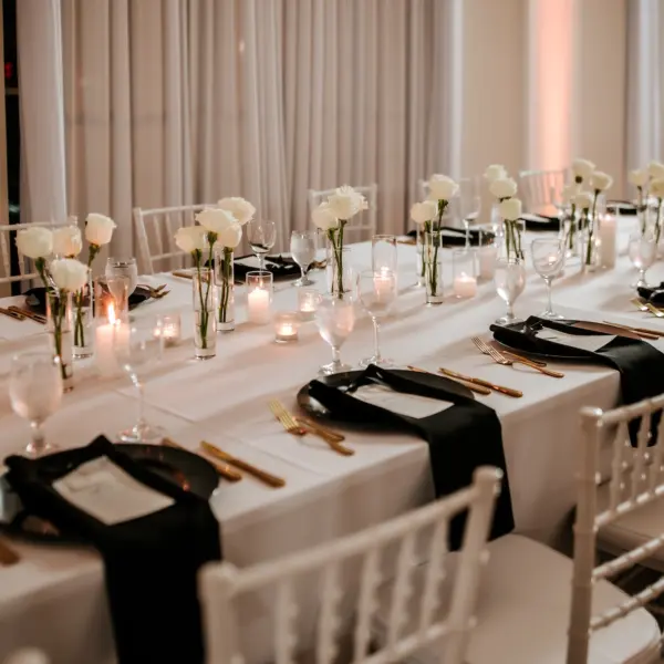 29Modern Black and White Wedding Inspiration - Timeless Black and White Downtown Tampa Wedding | The Vault Luxurious Black and White Ballroom Wedding Reception | Single Stem White Roses in Bud Vases Centerpieces Ideas | Romantic Candlelight Tablescape on White Linens Inspiration | Black Glass Chargers with Black Napkins and Gold Flatware Decor Ideas | Tampa Bay Florist Save The Date Florida | Kate Ryan Event Rentals