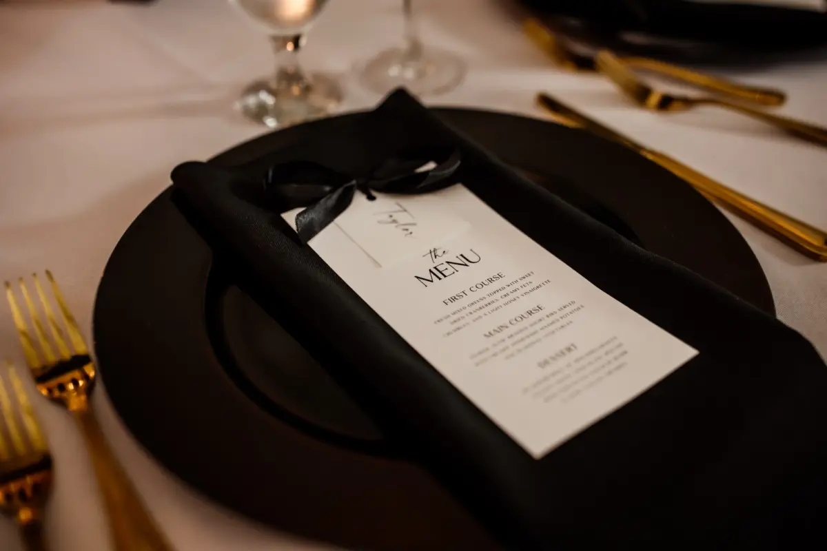30Modern Black and White Wedding Inspiration - Timeless Black and White Downtown Tampa Wedding | The Vault Black Glass Charger with Black Napkin and White Menu Card and Gold Flatware Wedding Reception Tablescape Decor Inspiration | Elegant Black and White Wedding Reception Decor Ideas | Kate Ryan Event Rentals