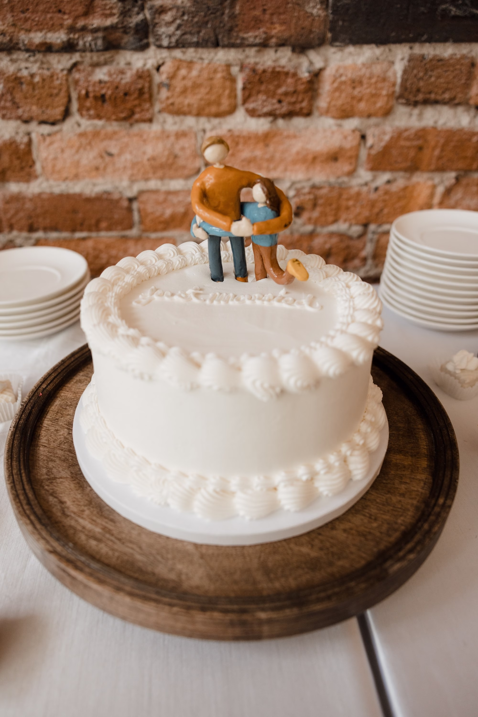 Single Tier Simple White Wedding Cake on Wooden Cake Stand with Ceramic Cake Topper Inspiration