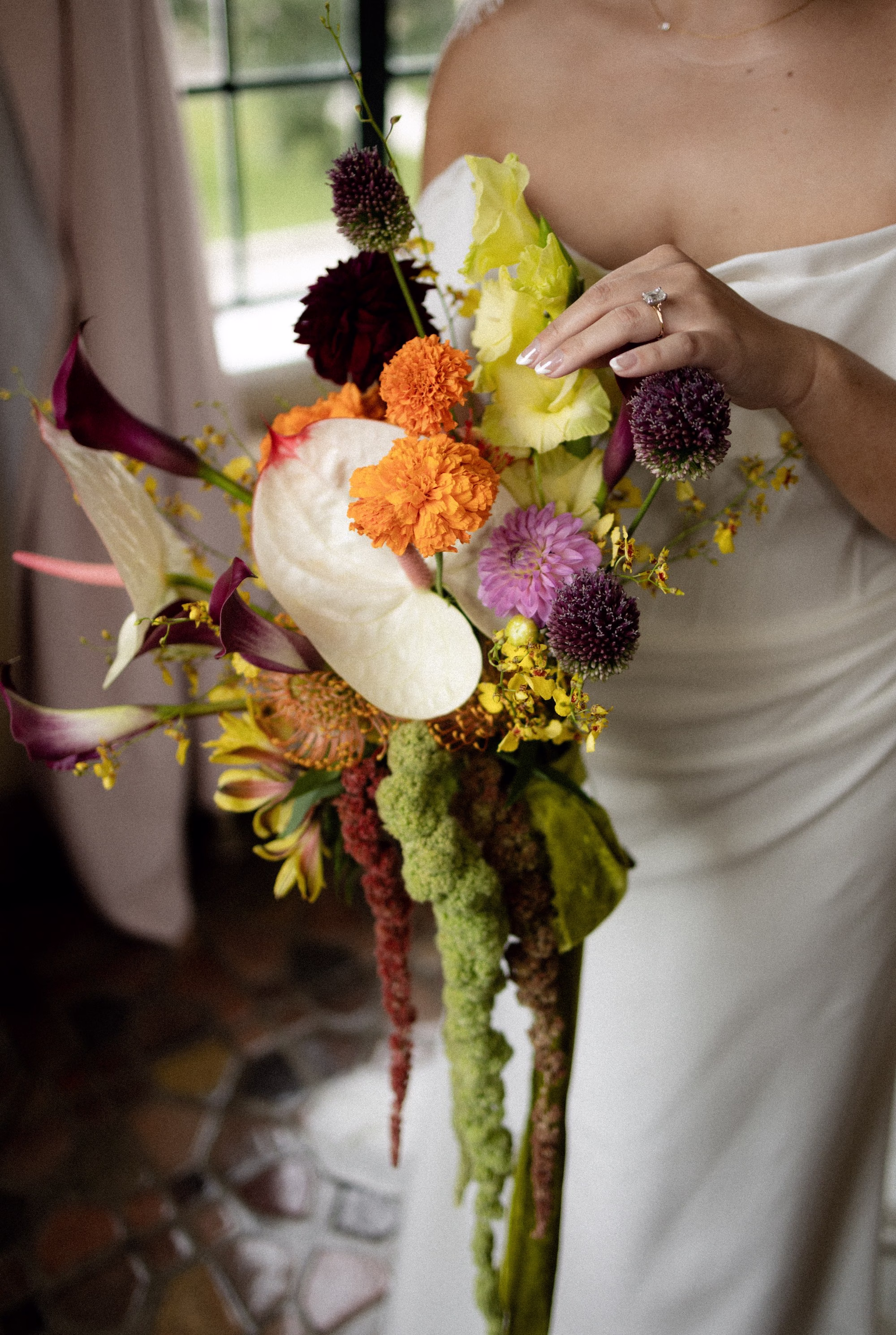 Tropical Fall Color Bridal Wedding Bouquet of Orange Carnations, White Calla Lillie, Purple Floral,and Greenery Thistle Arrangement Inspiration