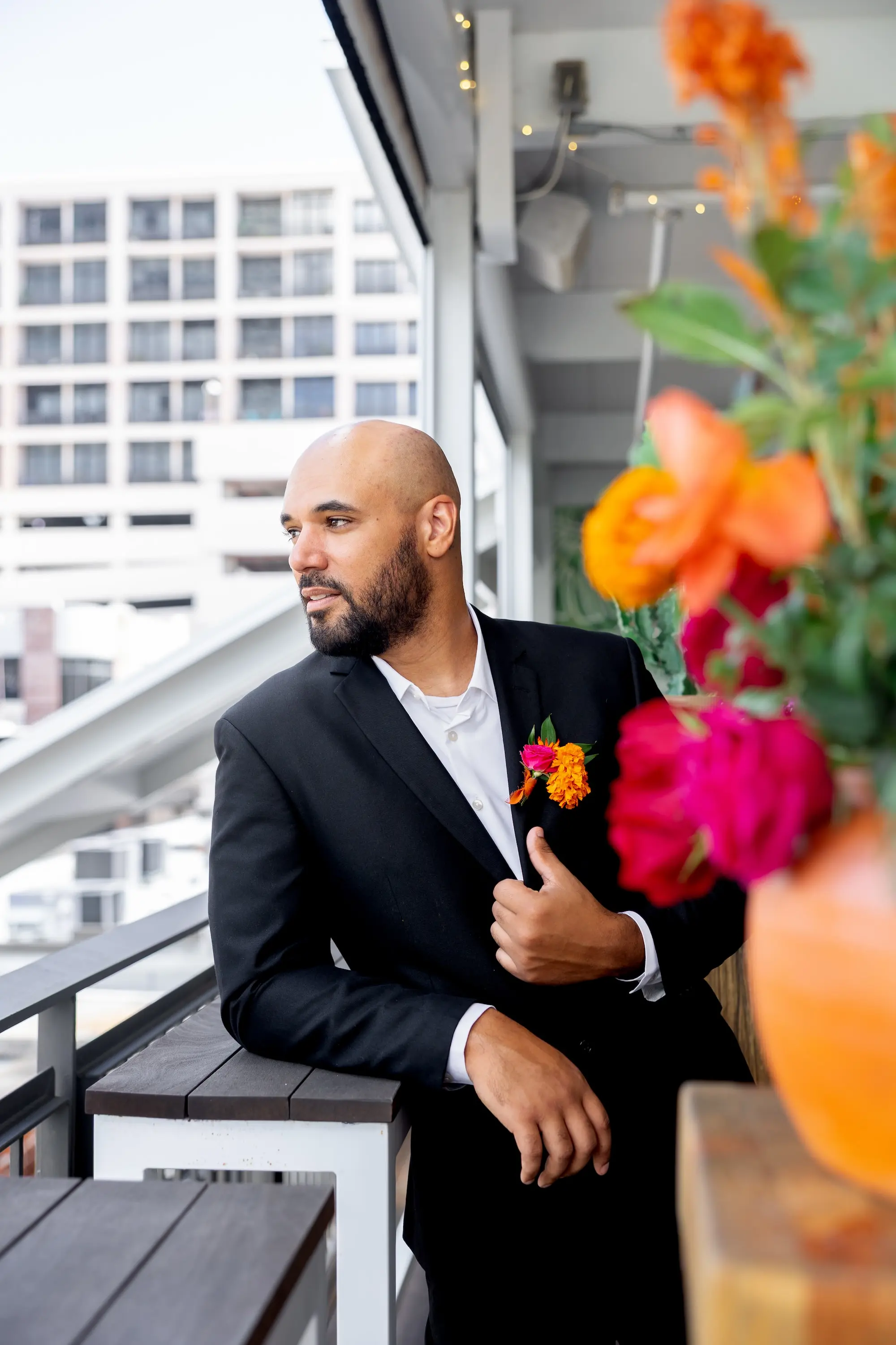 8Vibrant Southwestern Terracotta Pink and Orange Wedding Ideas - Vibrant, Rooftop Wedding Inspiration Shoot | Red Mesa Events Groom Wedding Portrait On Balcony of Wedding Venue | Vibrant Southwest Mexican Wedding Reception Ideas | Bright Pink, Orange, Rust Red, Floral Bridal Bouquet Inspiration | Tampa Bay Photographer Pine and Forge Photography | Content Creator Behind The Vows