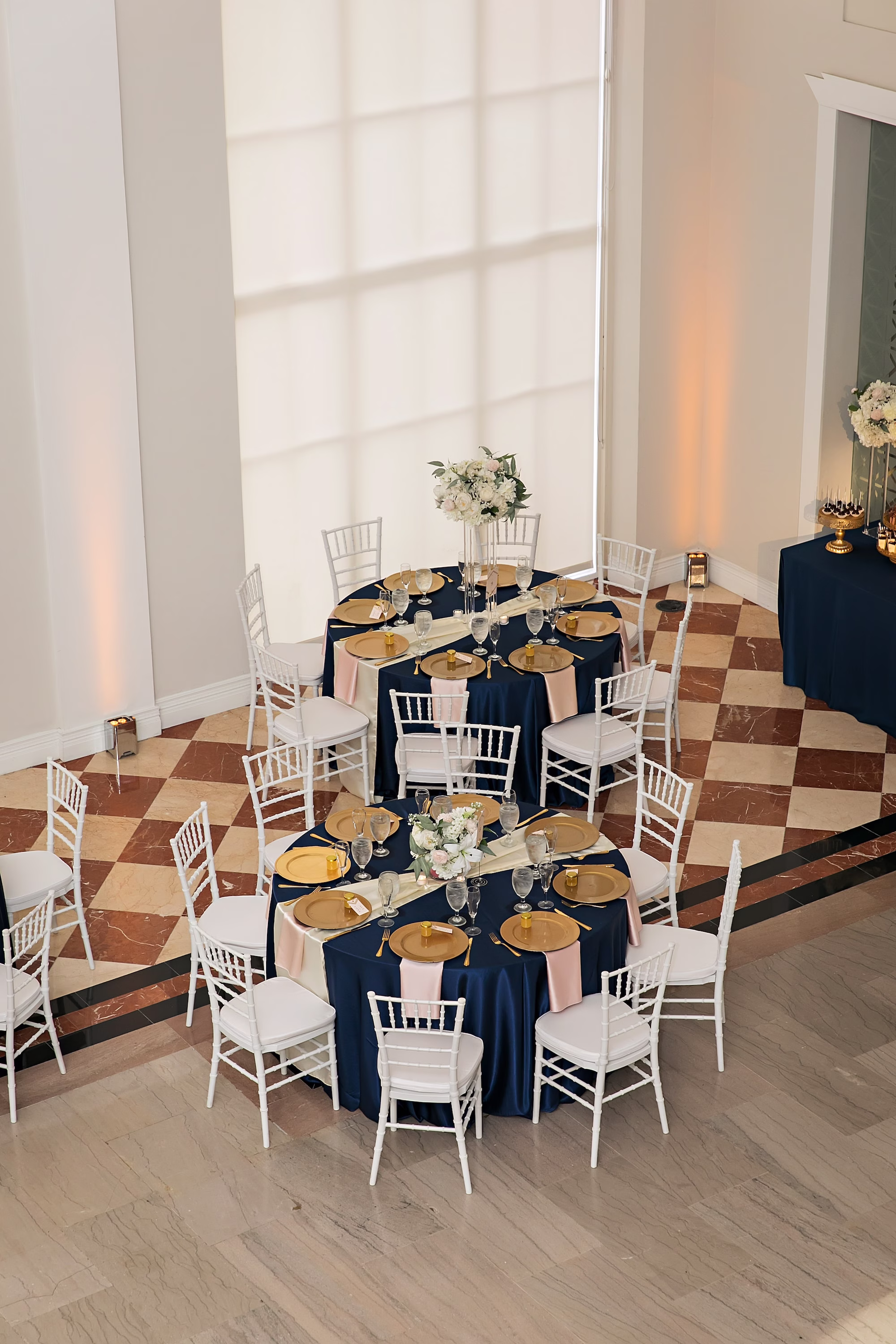 21Elegant Navy Blue and Blush PInk Wedding Ideas - Elegant, Navy and Blush Downtown Tampa Wedding | The Vault Old Glam Navy Blue and Blush Pink Winter Wedding Reception Decor Ideas | White and Blush Florals with Greenery Centerpiece Inspiration | Reception Tables with White Chiavari Chairs Ideas | Navy Blue Linens and Gold Chargers Reception Decor Inspiration | Tampa Bay Event Venue The Vault