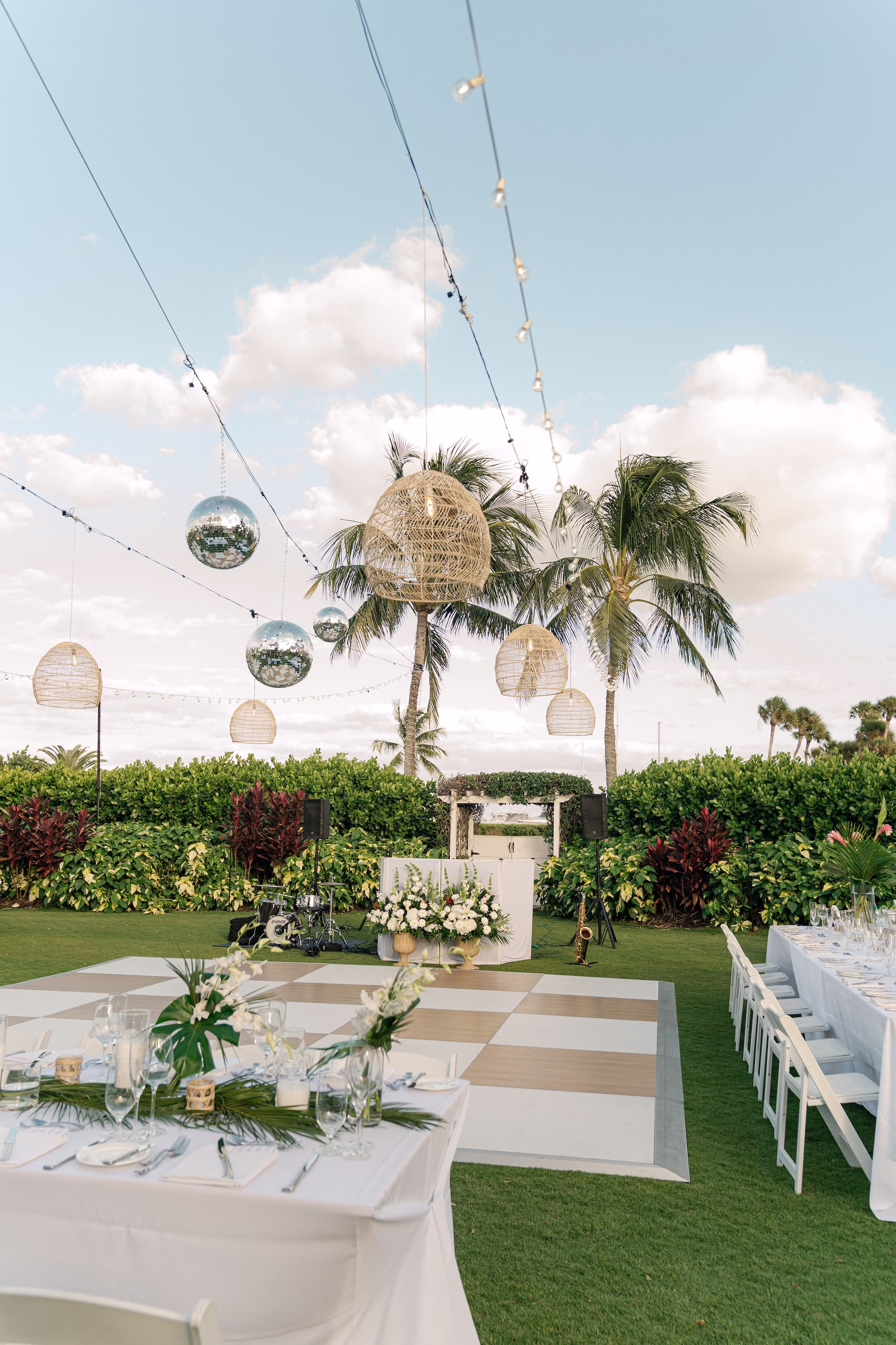 Glamourous Tropical Outdoor Wedding Reception Inspiration | Disco Balls and Hanging Wicker Lights Reception Decor Ideas | Long Tables with White Linens and White Chairs Inspiration | Lush White and Green Flower Arrangement Decor Ideas | Tampa Wedding Venue The Resort at Longboat Key Club