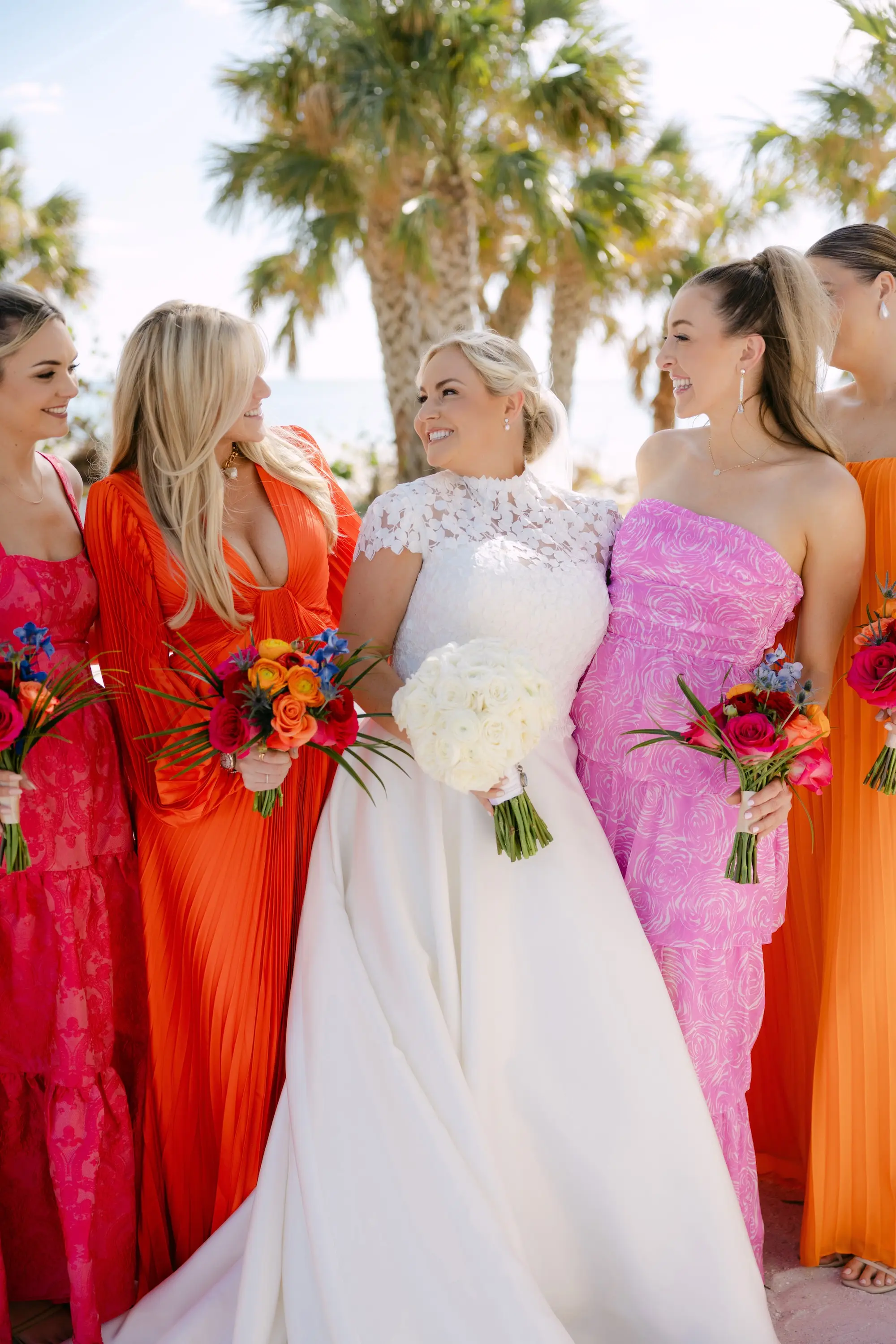 32Tropical Red and Orange Outdoor Florida Destination Wedding - Tropical Outdoor Sarasota Wedding | The Resort at Longboat Key Club Bride and Bridesmaids Wedding Portrait | Tropical Pink and Orange Mismatched Bridesmaid Dress Inspiration