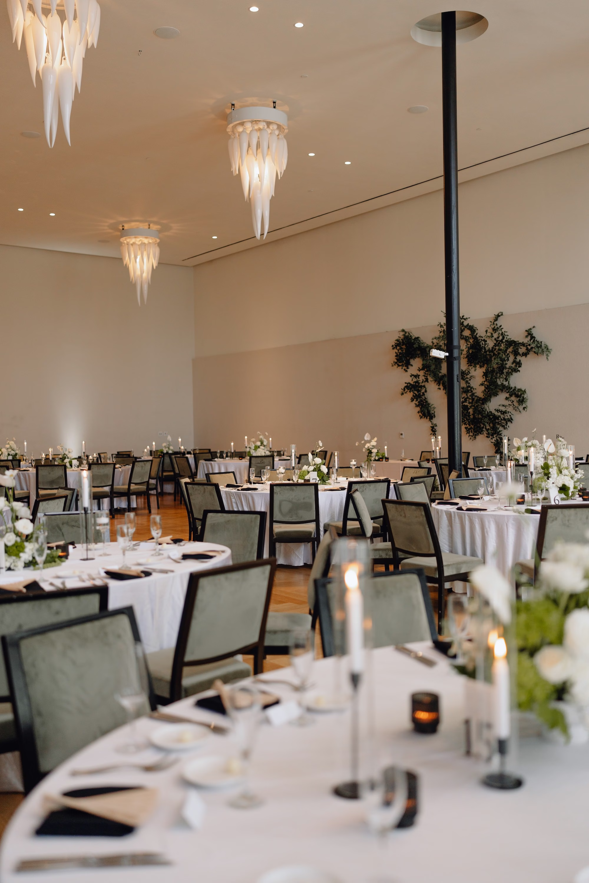 Elegant Botanical Black and White Industrial Wedding Reception Decor Ideas | White Linens with Black and White Table Numbers Reception Decor Ideas | White Florals with Lush Greenery Tablescape Inspiration | Black Napkins and Gold Fans WEedding Favors Ideas | Ybor Planner The Olive Tree Weddings | Valencia Ballroom, Event Venue Hotel Haya