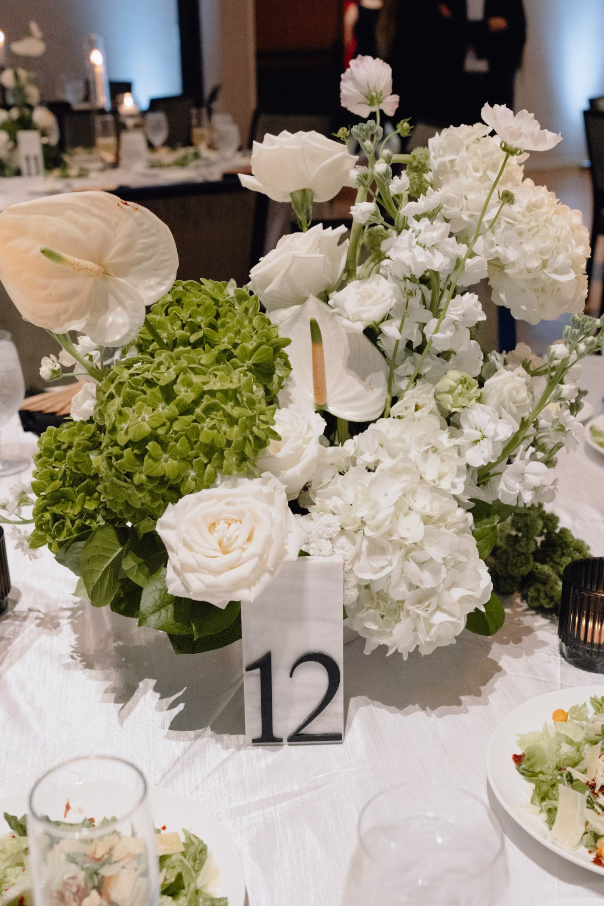 Elegant Botanical Black and White Industrial Wedding Reception Decor Ideas | Modern Florals with White Roses, Hydrangeas, Tropical Anthurium and Lush Greenery Wedding Reception Centerpieces Inspiration | Black and White Acrylic Reception Table Number Ideas | Ybor Planner The Olive Tree Weddings