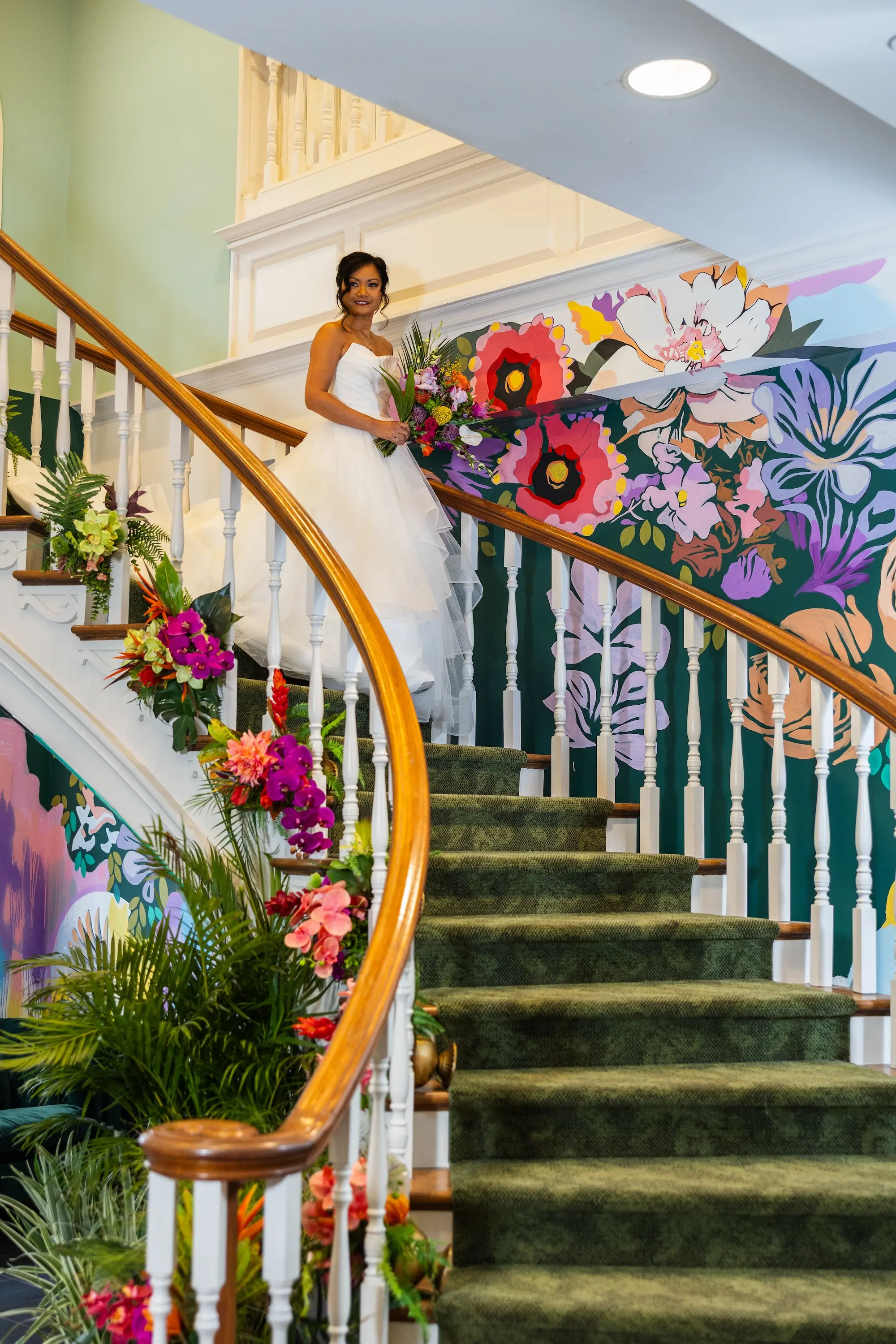 Bride Coming Down Spiral Staircase Wedding Portrait | White Strapless Tulle Wedding Ballgown Ideas | Bright Coral, Mauves Florals with Deep Green Palms Tropical Floral Decor Inspiration | Tampa Bay Wedding Venue The Spiral Staircase | Sarasota Boutique Truly Forever Bridal