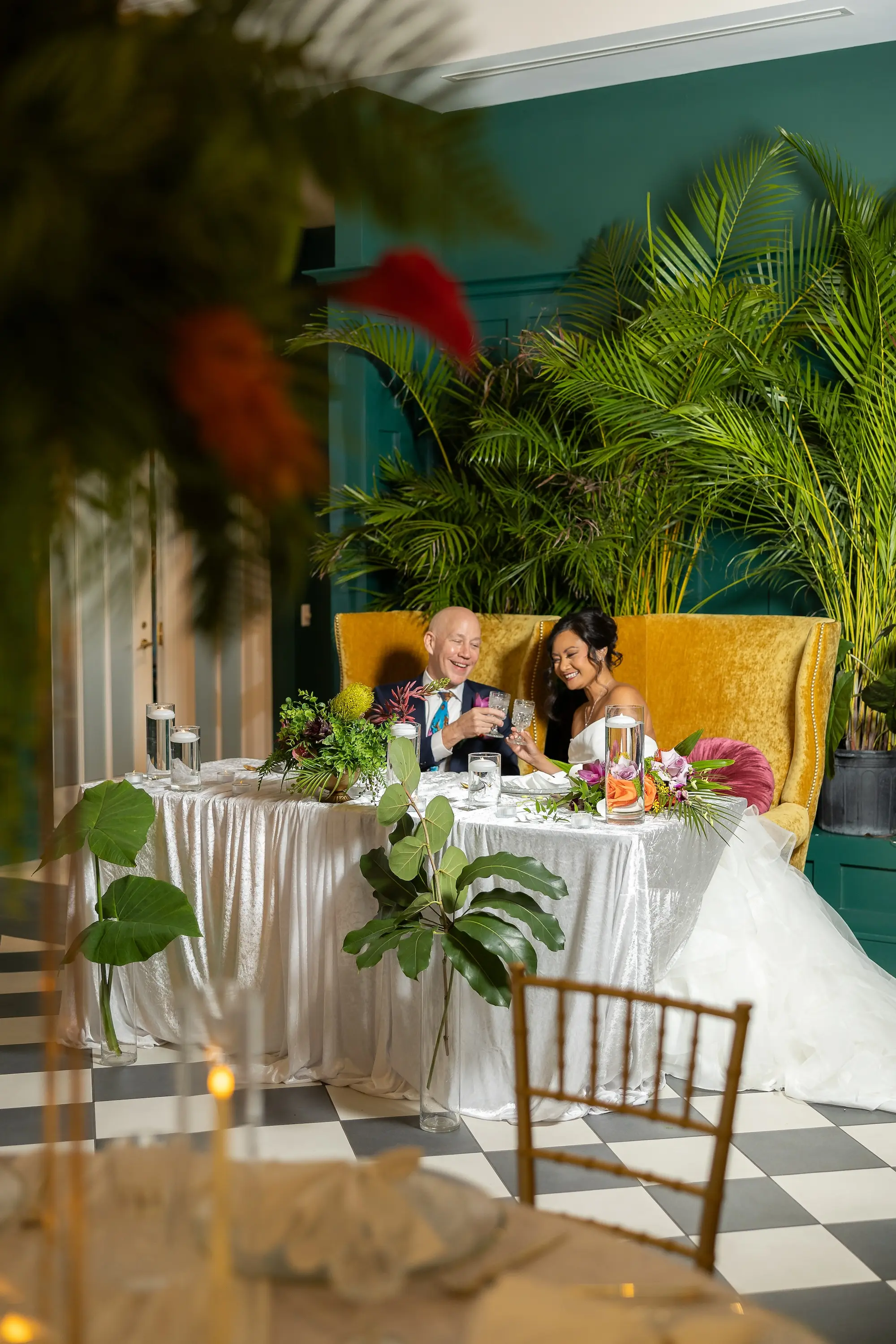 Modern Classic Wedding Inspiration | Bride and Groom on Mustard Yellow Velvet Chairs Sweetheart Table Ideas | Black and White Checkered Reception Floor Inspiration | Tropical Palms Greenery Decor Ideas | Tampa Bay Wedding Venue The Spiral Staircase