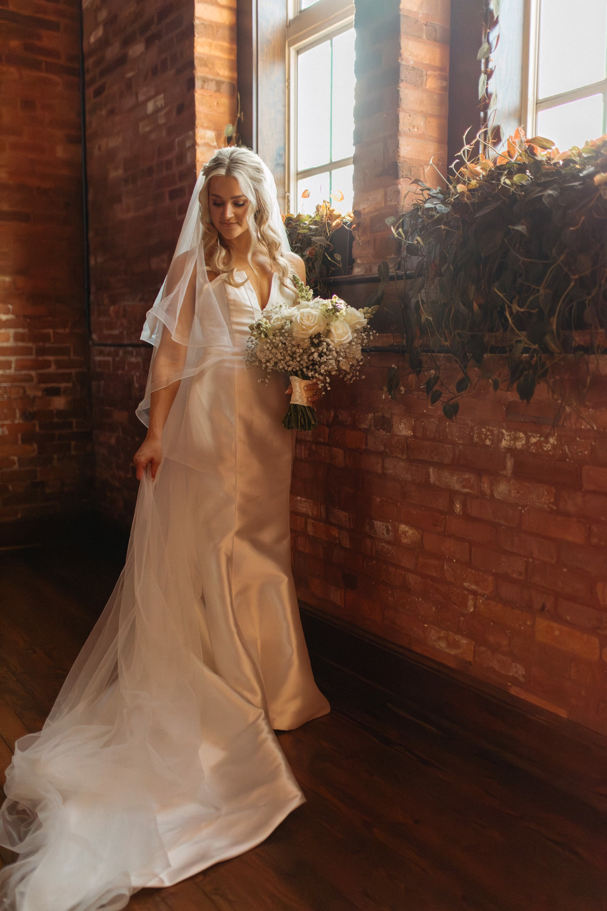 Groom's Reaction to Bride Walking Down Wedding Ceremony Aisle | White Roses and Baby's Breath in Greenery Floral Column Altar Wedding Ceremony Decor Inspiration | White Rose Petals Wedding Ceremony Aisle Decor Ideas | Clearwater Florist Lemon Drops Wedding and Events