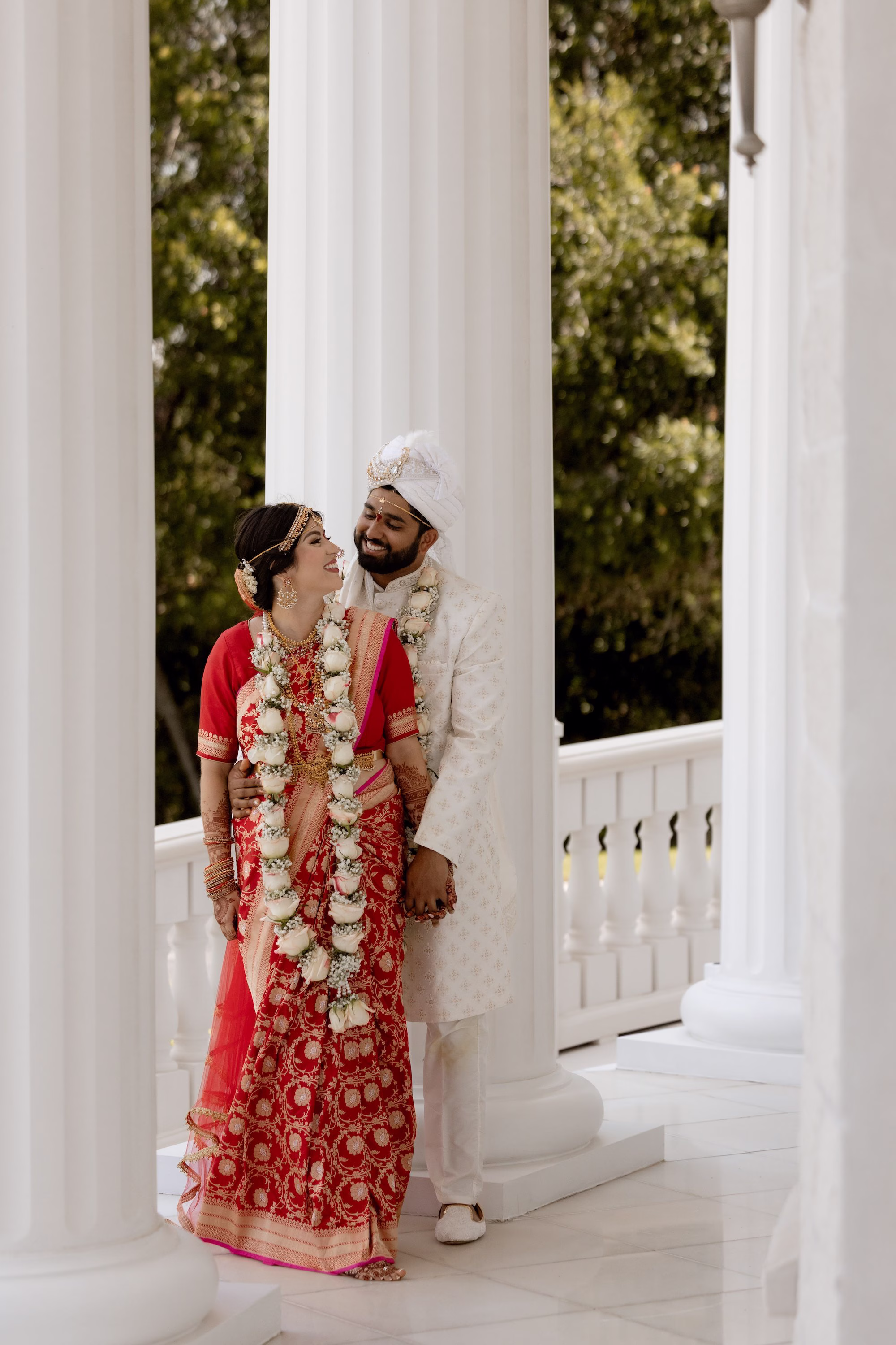Bride and Groom Wedding Portrait | Red and Gold Bridal Saree Inspiration | White Groom Sherwani, Churidar and Sehra Ideas | Traditional Indian Bride and Groom Attire Inspiration | Light Pink and Baby's Breath Flower Garland Varmala, Jaimala Indian Wedding Ceremony Tradition | Tampa Bay Event Venue Whitehurst Gallery | Photographer Evoke Photo and Film
