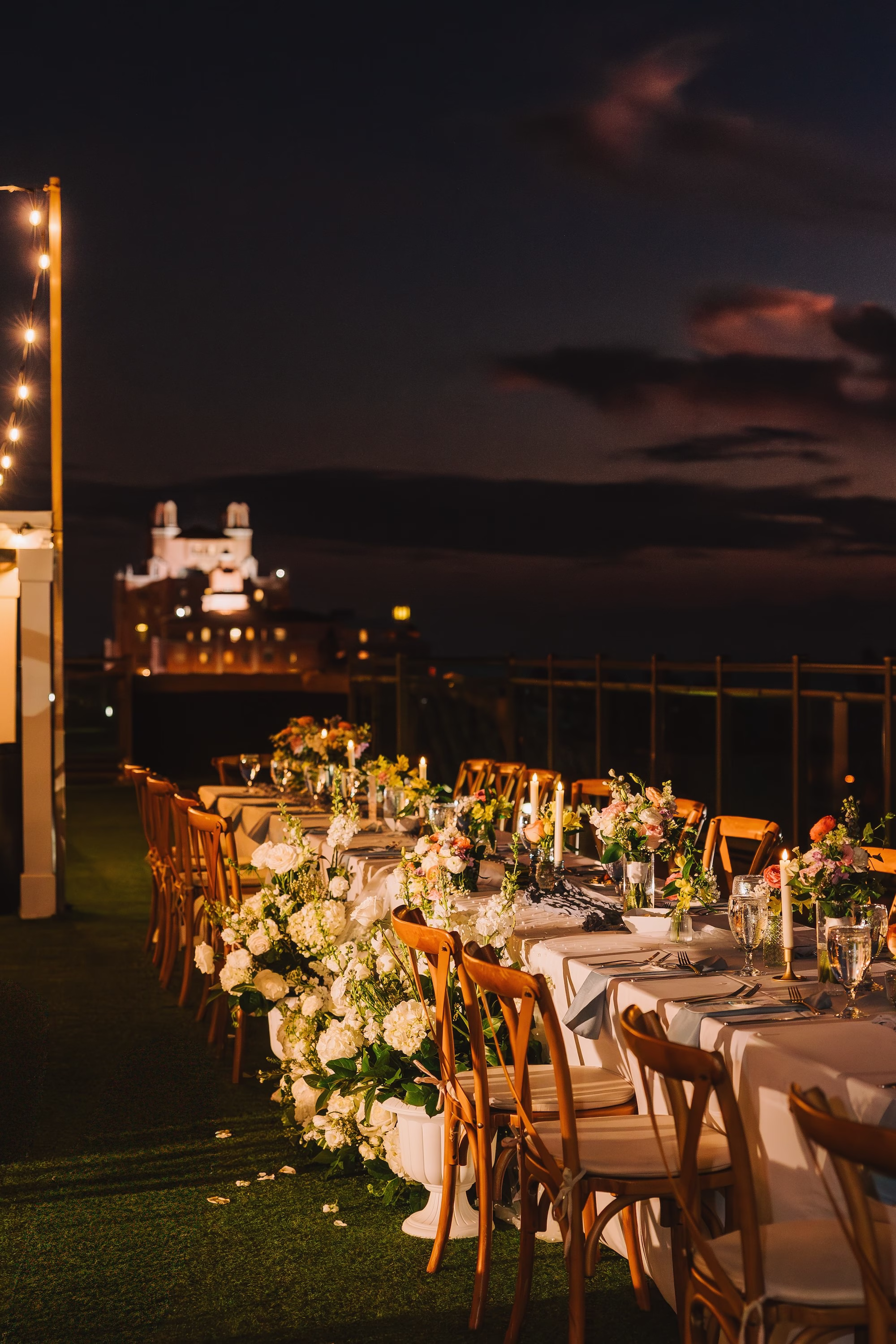 43Coastal Blue and White Rooftop Florida Wedding Ideas St Pete Venue Hotel Zamora - Romantic Blue Coastal St. Pete Beach Wedding | The Hotel Zamora Coastal Elegant Waterfront Rooftop Wedding Reception Inspiration | Long Feasting Table with Rustic Wooden Cross Back Chairs and White Linens Tablescape Ideas | Monochromatic White Flower Arrangement Decor with Roses and Hydrangeas Inspiration | St Pete Beach Wedding Venue Hotel Zamora | St Petersburg Wedding Planner Seashine Weddings