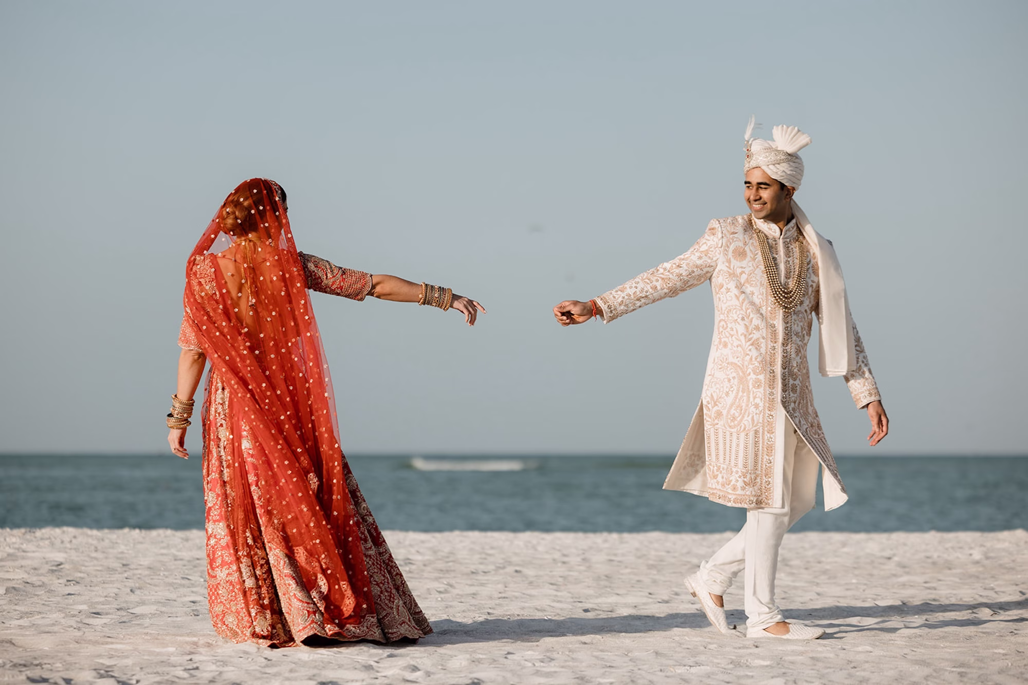 11Tropical Pink and Red Sarasota Beach Indian Wedding Ceremony - Vibrant Pink and Gold Multicultural Sarasota Wedding | Powel Crosley Estate Bride and Groom Beach Wedding Portrait | Bright Red and Gold Bride Lehenga by Kalighata at Kynah Ideas | Groom Beaded Off-White Sherwani Inspiration | Indian Culture Wedding Ideas | Sarasota Beach Event Venue The Resort at Longboat Key Club | Photographer Evoke Photo and Film